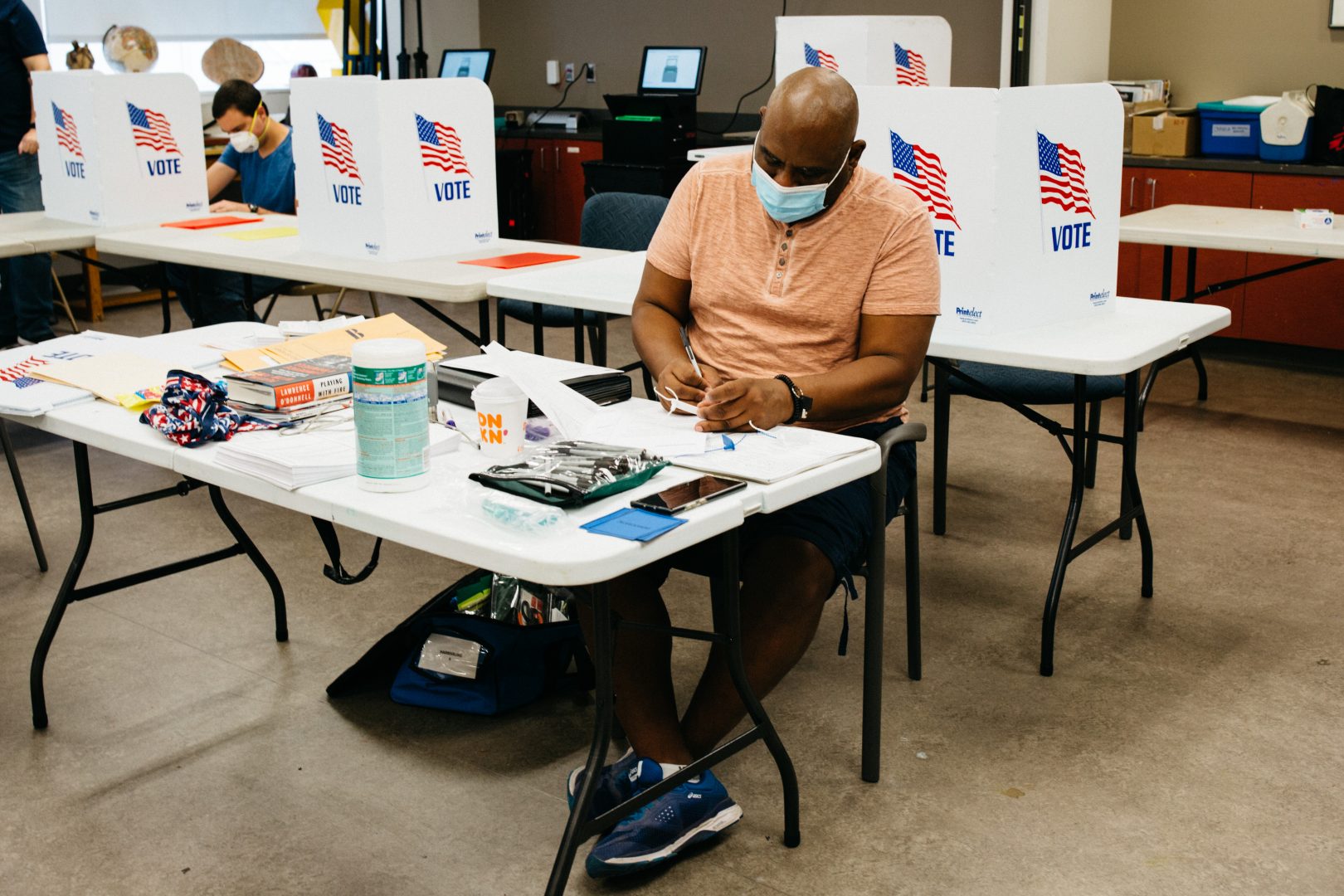 An election worker fills out paperwork at Harrisburg's 6th ward at the Susquehanna Art Museum, on June 2, 2020. Poll workers across the state were issued face masks to help stop the spread of coronavirus.