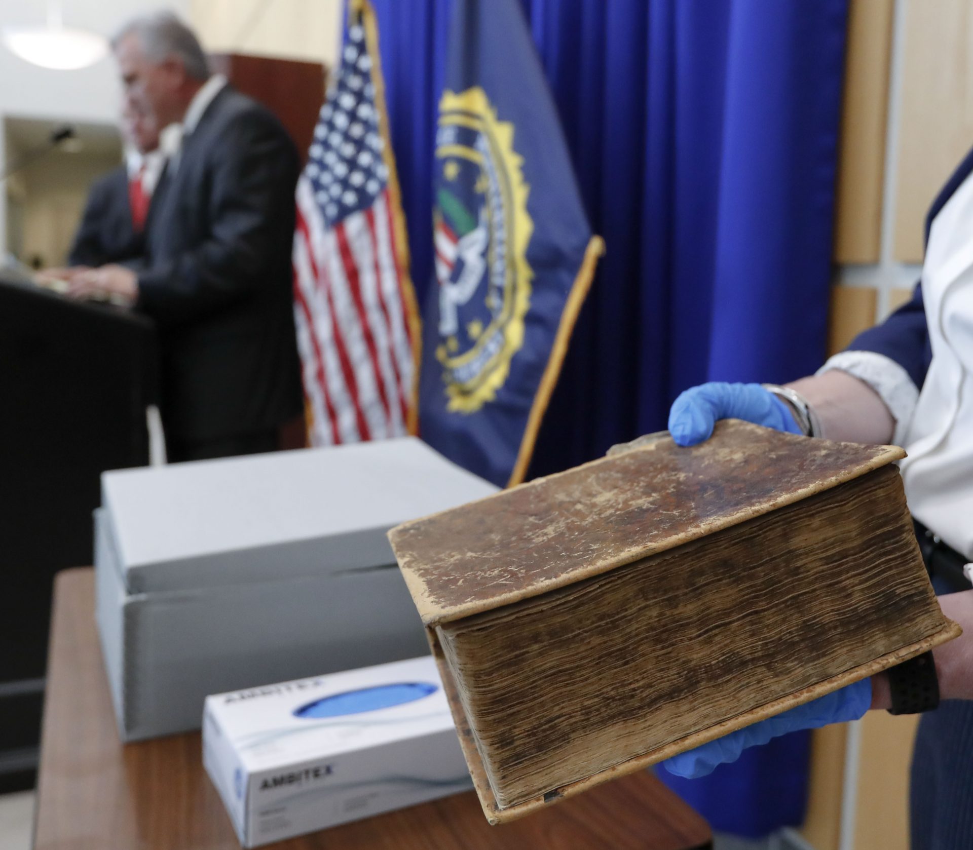 FBI Special Agent in Charge Robert Jones, left, and Allegheny County District Attorney Stephen Zappala, center, talk about the efforts and ultimate recovery of the Breeches Edition Bible that FBI supervisory special agent Shawn Brokos, right, holds during a news conference, Thursday, April 25, 2019, in Pittsburgh. The Bible that was published in 1615 was stolen from the Carnegie Library in Pittsburgh in the 1990's. It was traced to the American Pilgrim Museum in Leiden, Netherlands.