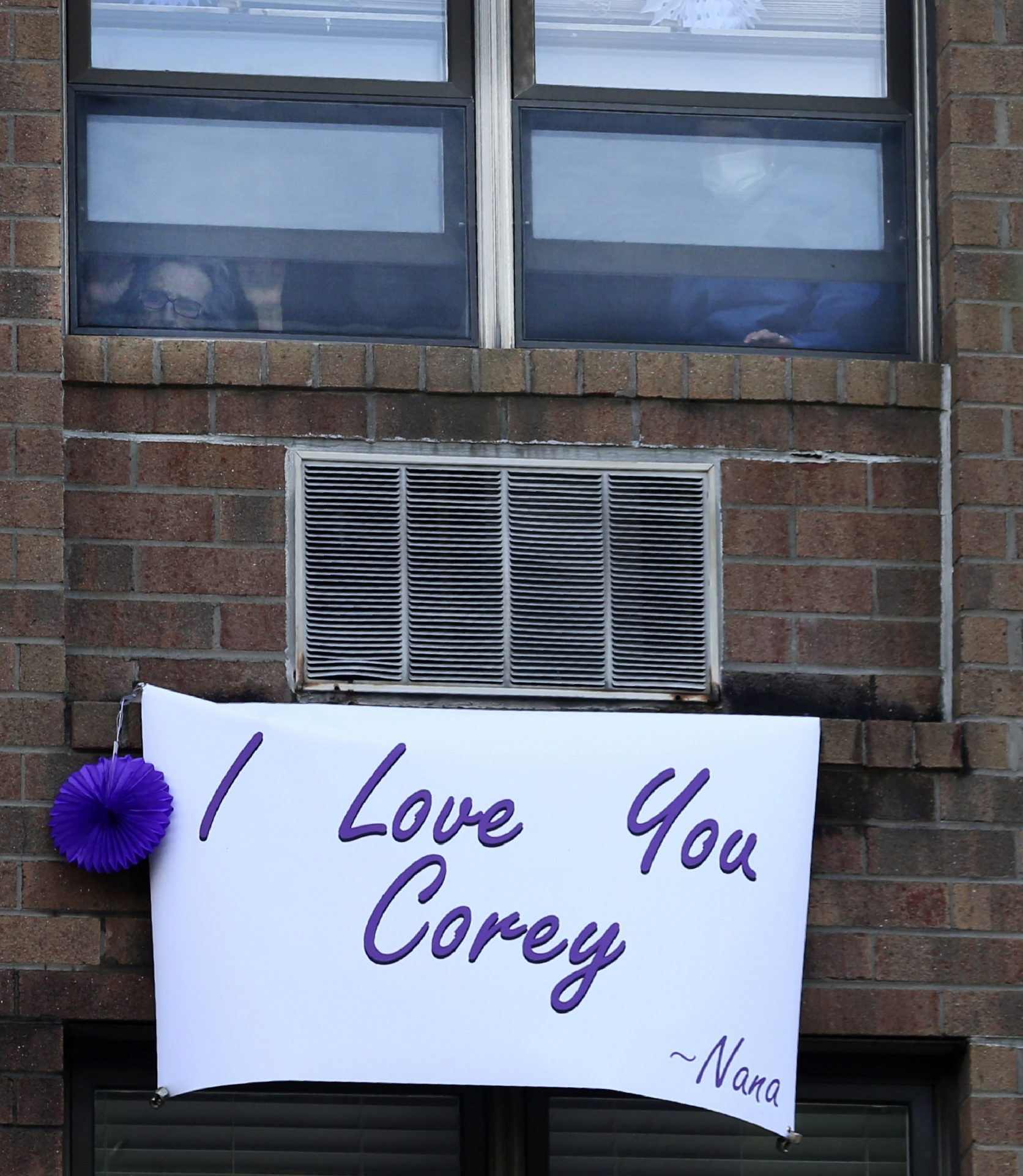 Ruth Andres, 98, left, looks through her fourth-story window at Allied Services Skilled Nursing & Rehab Center as she awaits the arrival of grandson Corey Cappelloni in Scranton, Pa., Friday, June 19, 2020. Running roughly 218 miles, Cappelloni ran seven ultramarathons in seven days to visit his grandmother and raise awareness about older adults who have been isolated during the coronavirus pandemic.