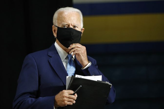 Democratic presidential candidate, former Vice President Joe Biden puts on a face mask to protect against the spread of the new coronavirus as he departs after speaking at Alexis Dupont High School in Wilmington, Del., Tuesday, June 30, 2020.