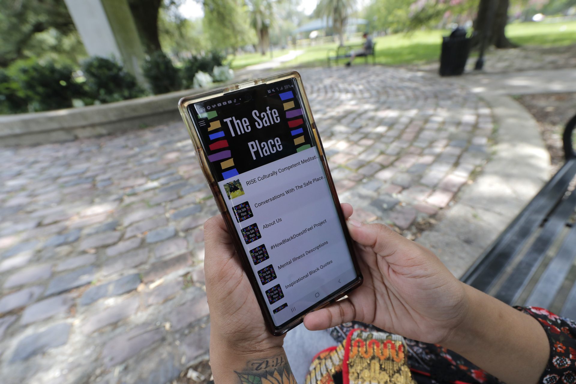 Jasmin Pierre poses for a photo with her smartphone app, in New Orleans, Thursday, July 2, 2020. Pierre, who survived multiple suicide attempts, doesn't want people struggling alone. She created The Safe Place, a free Black-oriented mental health app that's seen more signups during the pandemic.