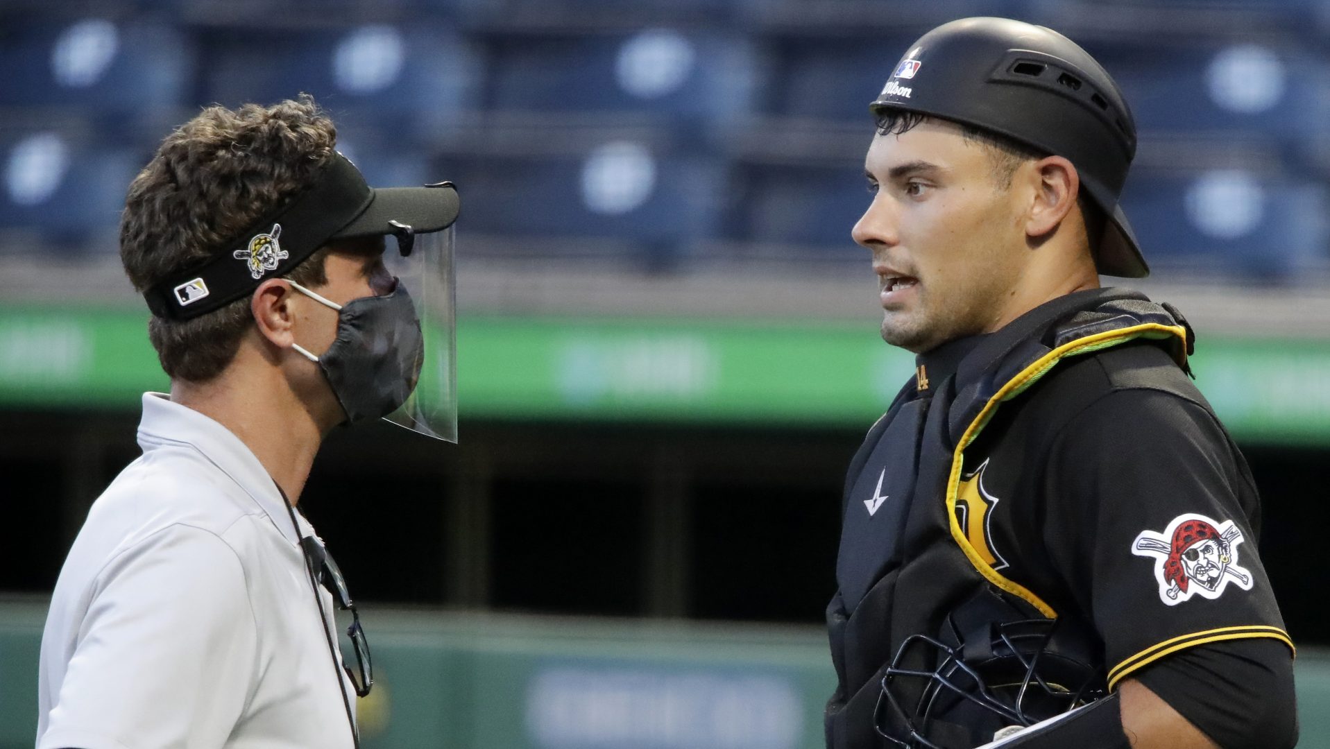 Pittsburgh Pirates catcher Luke Maile, right, talks with a trainer during an intrasquad game during the team's baseball practice at PNC Park in Pittsburgh, Wednesday, July 15, 2020.