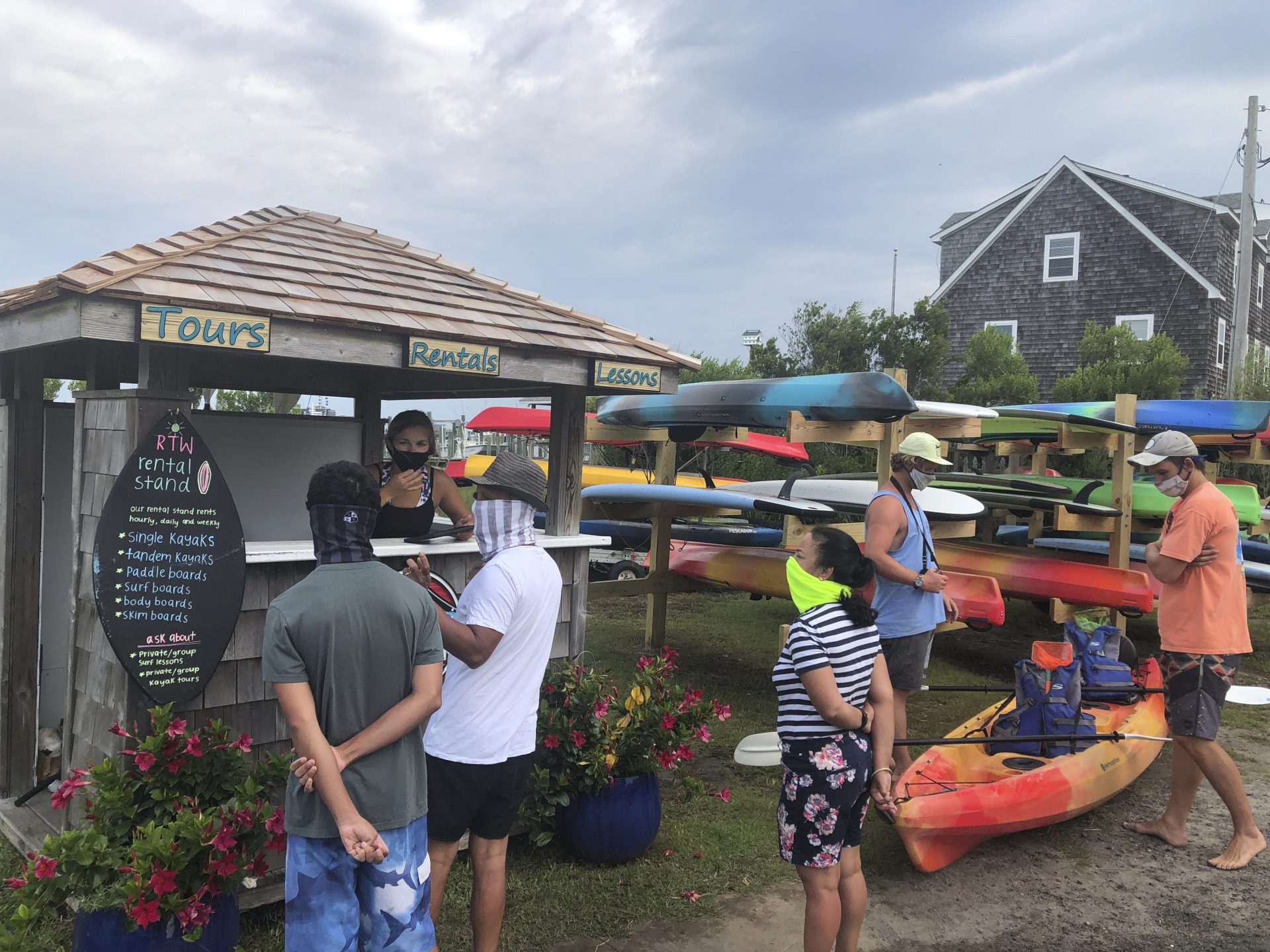 Tourists to North Carolina's Ocracoke Island visit Ride the Wind Surf Shop on June 25, 2020. The secluded travel destination was ravaged by Hurricane Dorian in September and then hit with coronavirus-related travel restrictions in the spring. Residents and business owners are hoping to recoup some of their losses as tourists return, albeit in smaller than usual numbers. But they're wary of a possibly busy hurricane season ahead.