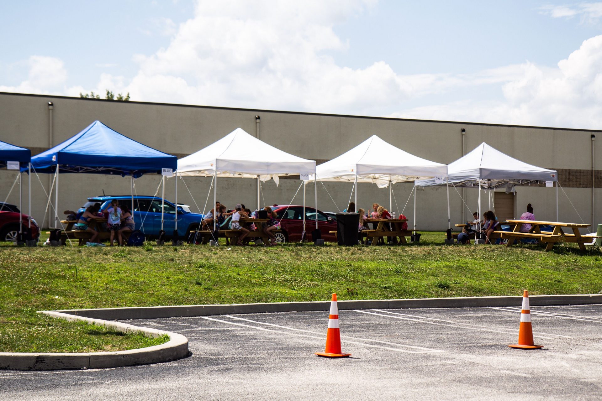 Campers at the Upper Merion Dance and Gymnastics Center eat outside at picnic tables.