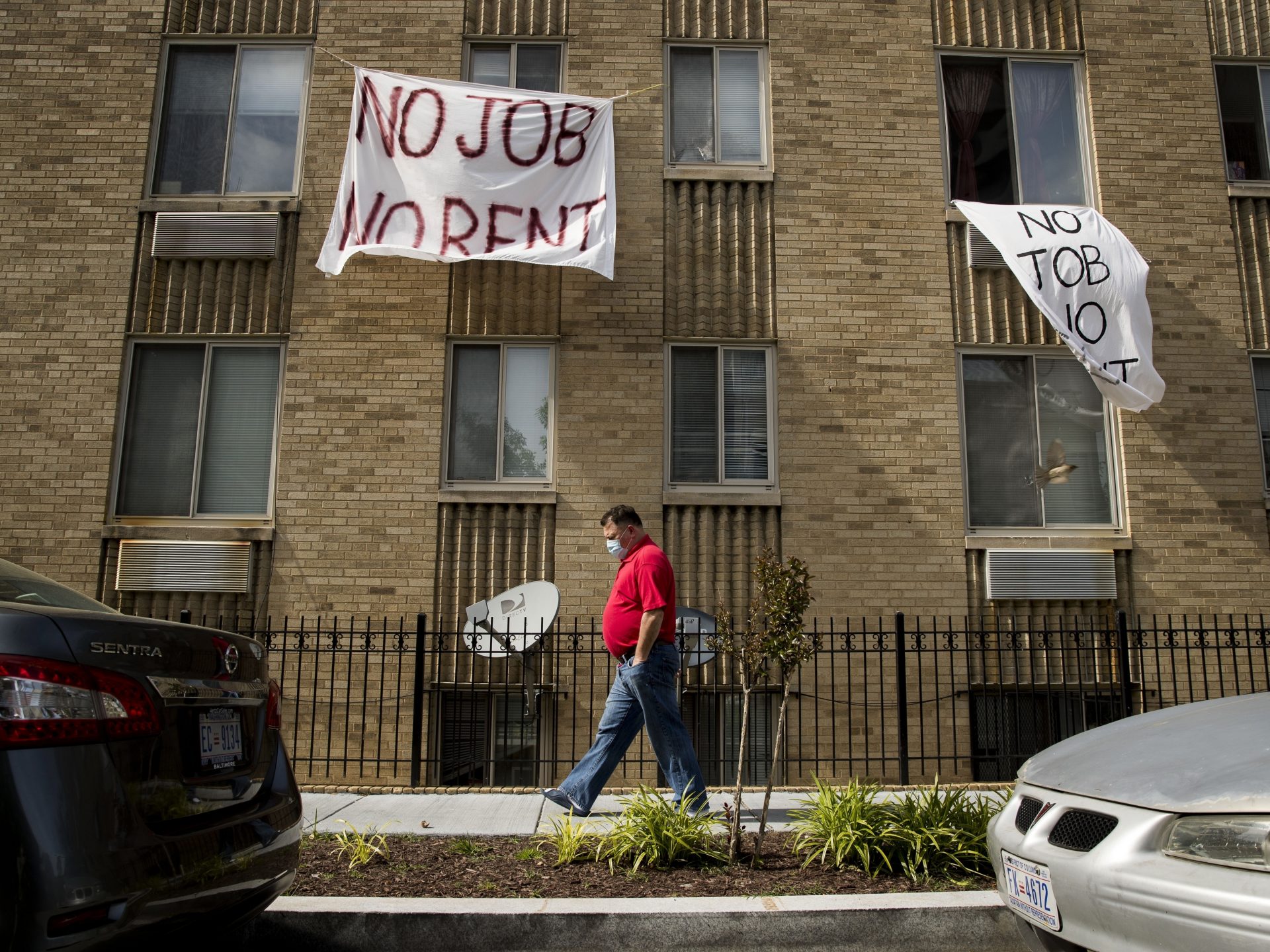 FILE PHOTO: In this May 20, 2020, file photo, signs that read "No Job No Rent" hang from the windows of an apartment building during the coronavirus pandemic in Northwest Washington.