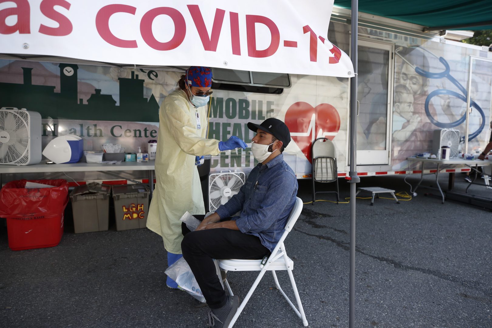 Nurse Tanya Markos administers a coronavirus test on patient Ricardo Sojuel at a mobile COVID-19 testing unit, Thursday, July 2, 2020, in Lawrence, Mass.