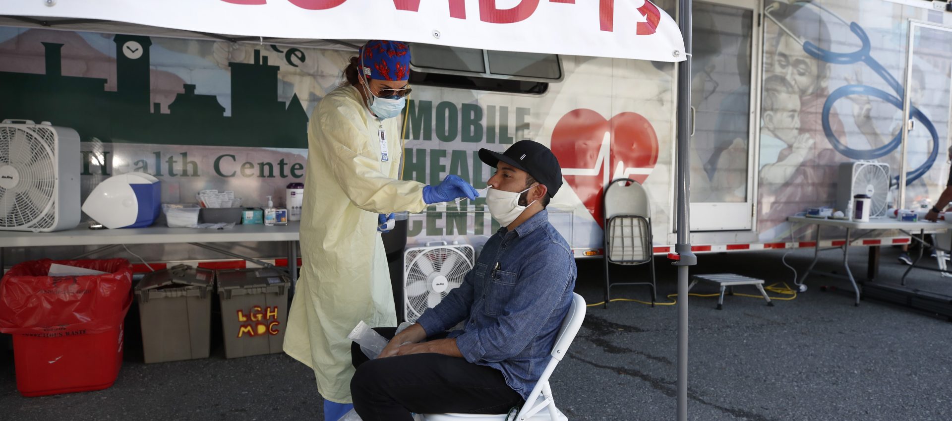 Nurse Tanya Markos administers a coronavirus test on patient Ricardo Sojuel at a mobile COVID-19 testing unit, Thursday, July 2, 2020, in Lawrence, Mass.