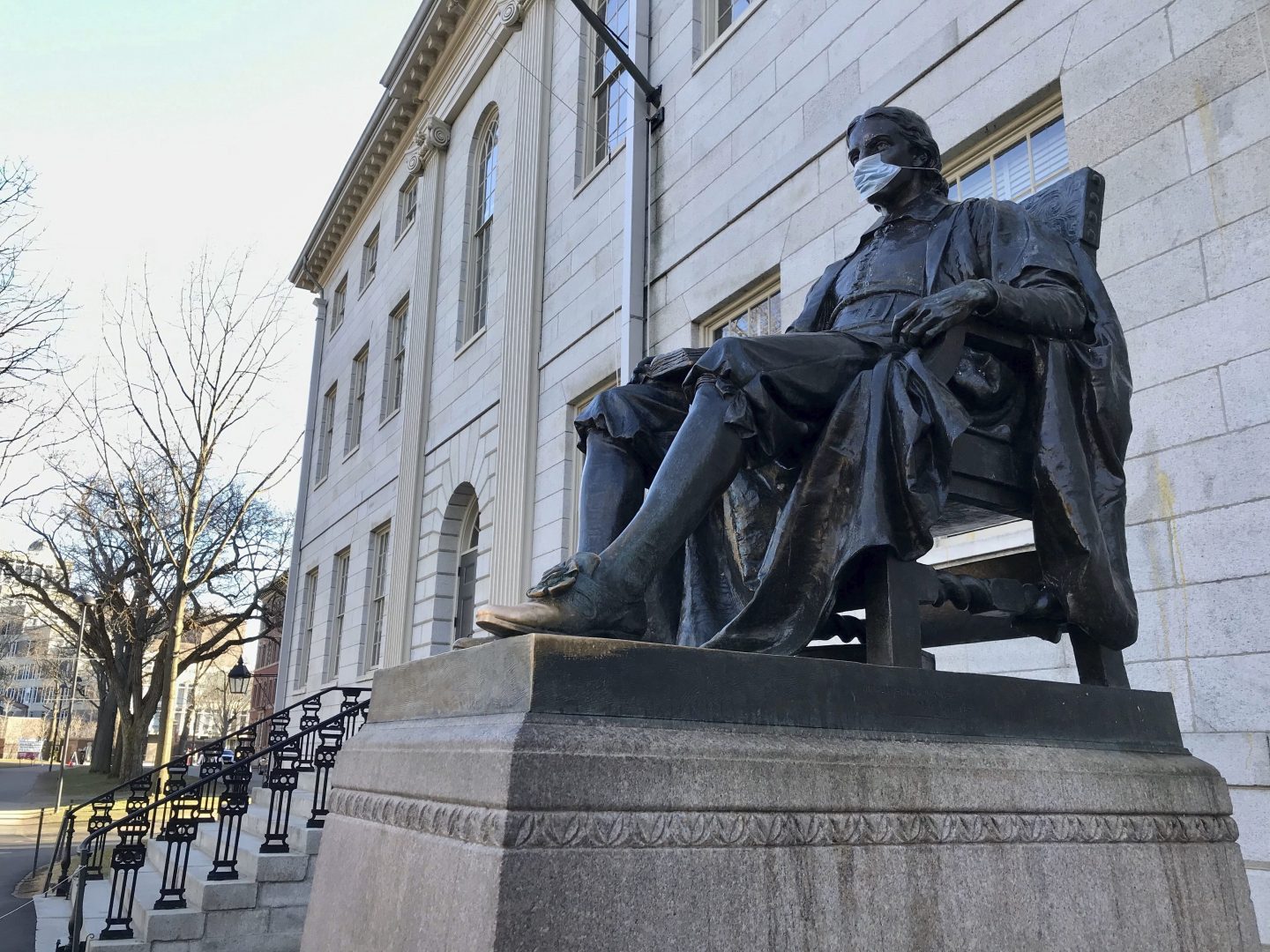 The John Harvard statue at Harvard University, a popular tourist attraction at the campus in Cambridge, Mass, sits adorned with a medical mask as students prepared to leave campus, Saturday, March 14, 2020. 
