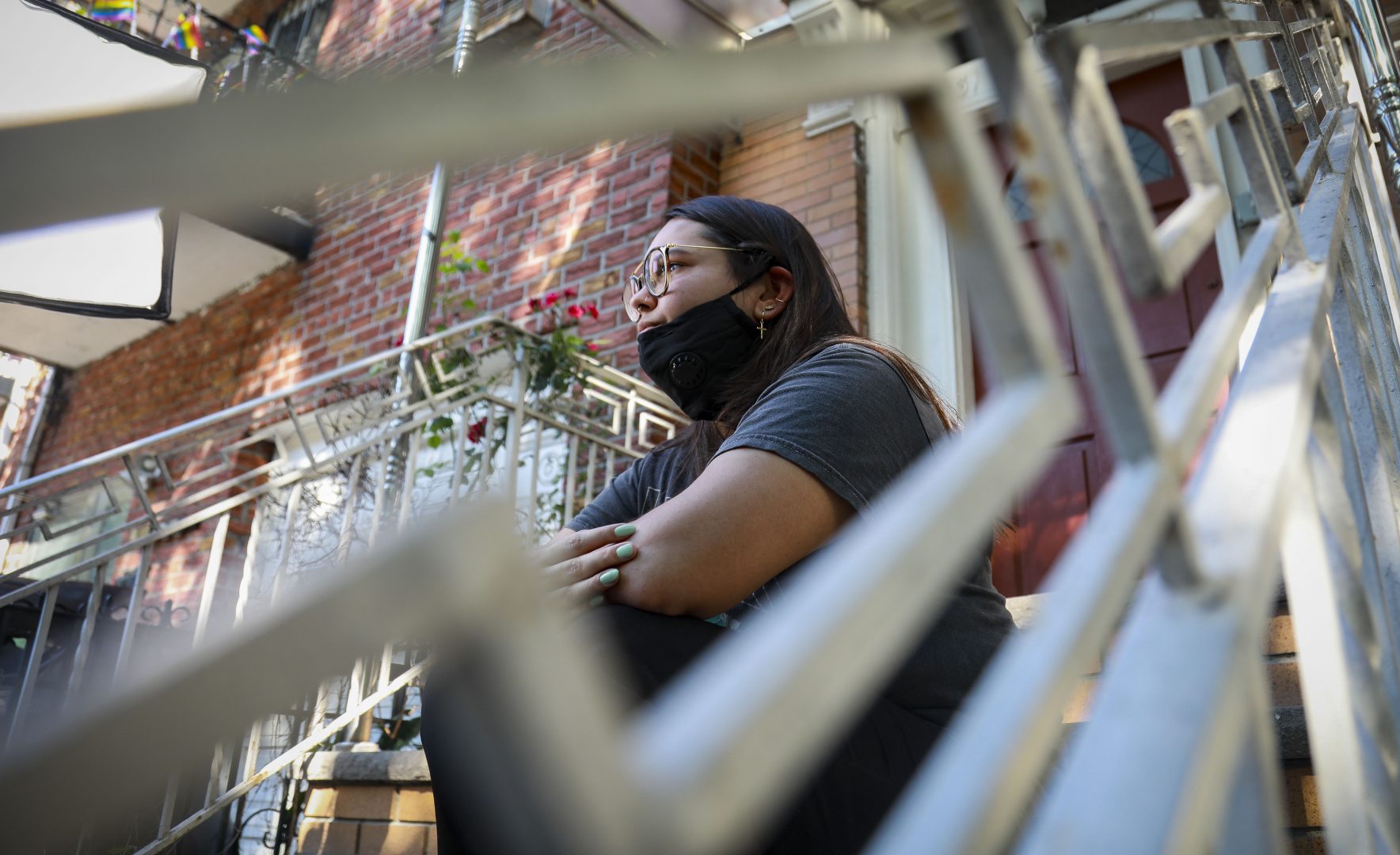 Natalia Afonso, 27, an international student from Brazil at Brooklyn College, sits on a stoop outside her home during an interview, Thursday, July 9, 2020, in New York. Afonso, who is studying teaching education and finished her first semester this spring, said she has lived in the U.S. for 7 years and 