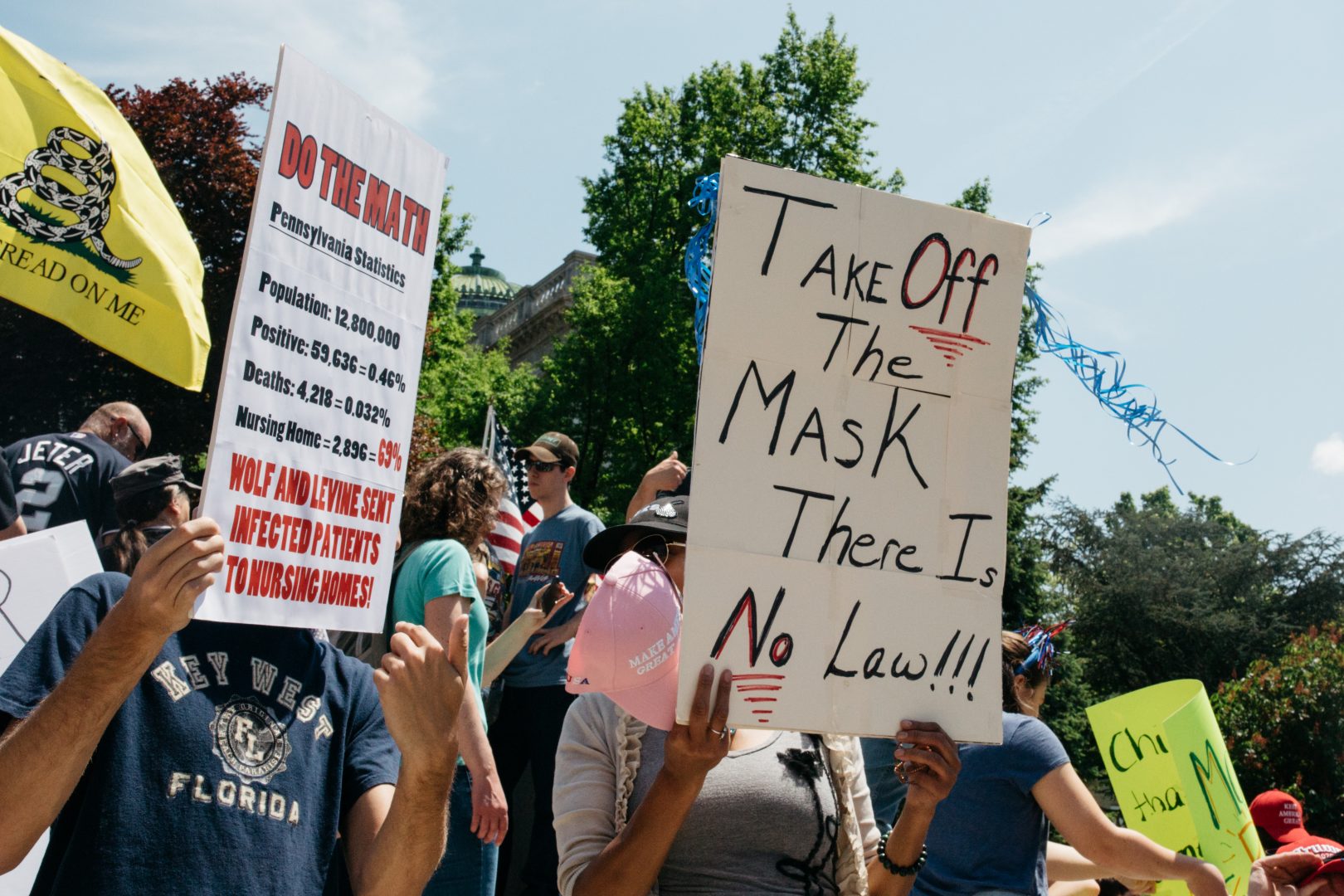 A woman holds an anti-mask sign at a May 15, 2020, ReOpen PA protest outside the state capitol in Harrisburg, Pa.
