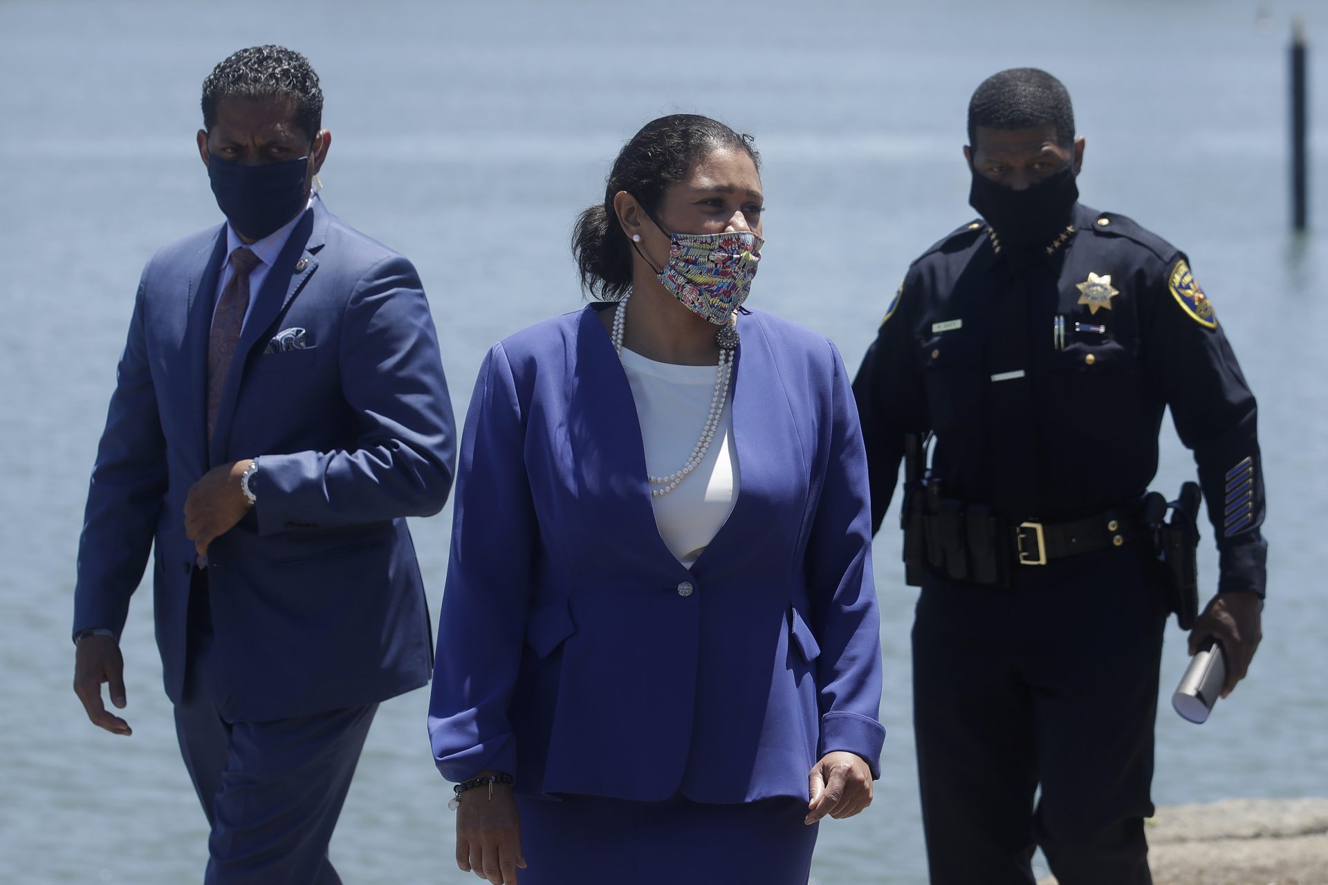 Mayor London Breed, center, and San Francisco Police Chief William Scott, right, arrive at a news conference about the shooting death of Jace Young in San Francisco, Tuesday, July 7, 2020.