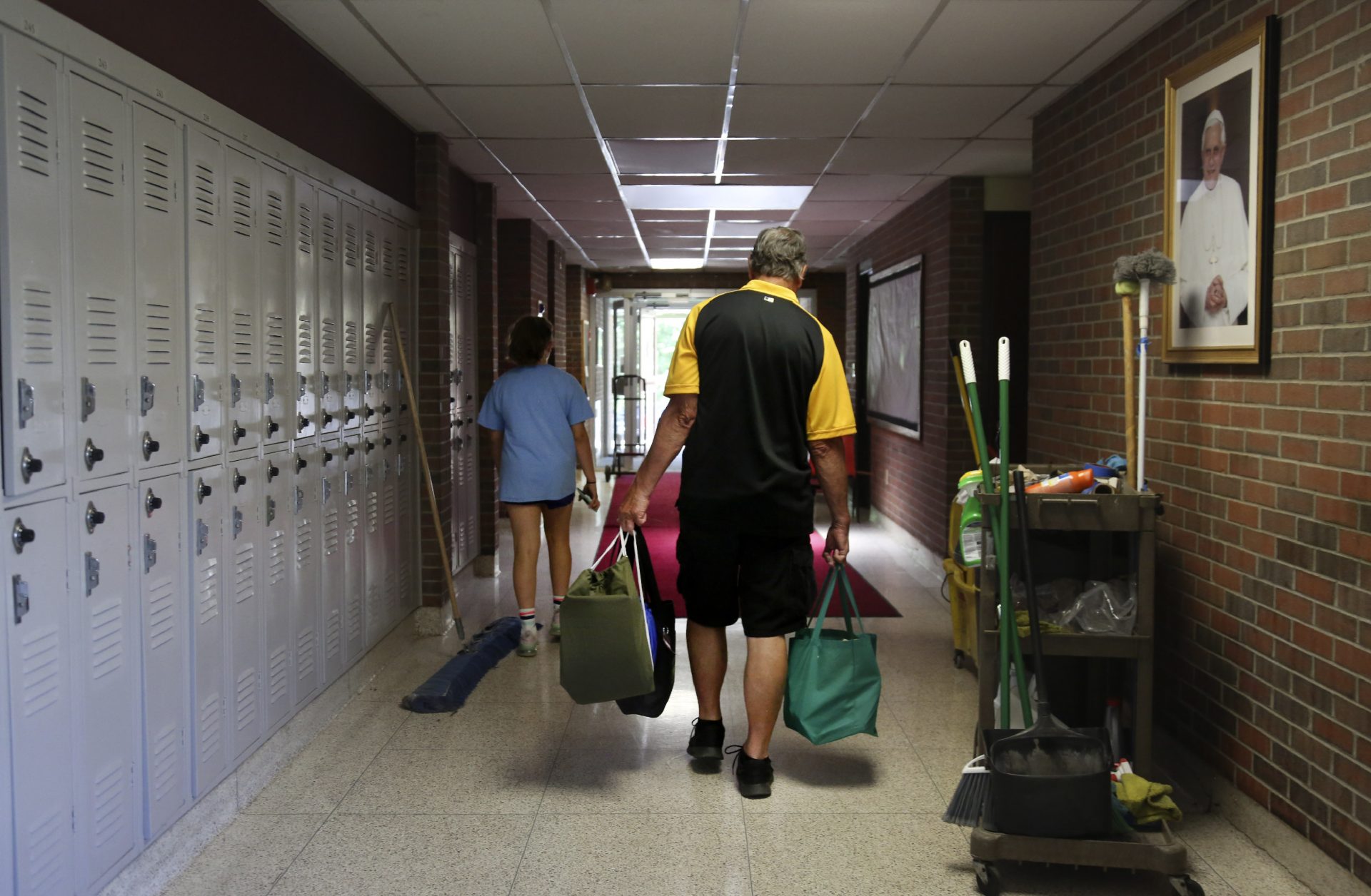 Cesa Pusateri, 12, and her grandfather, Timothy Waxenfelter, principal of Quigley Catholic High School, leave with his collection of speech and debate books after the recent closure of the school in Baden, Pa., Monday, June 8, 2020.