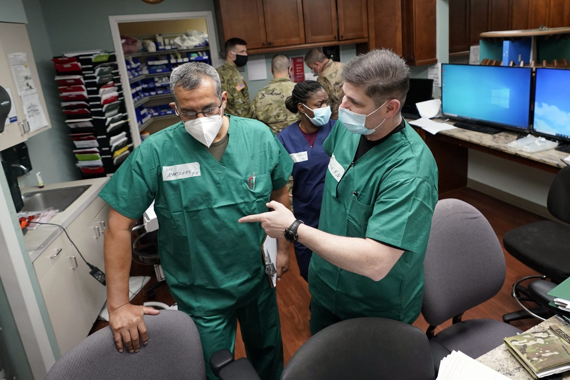 Registered nurses Army Lt. Col. Oswaldo Martinez, left, and Maj. Andrew Wieher, right, with the Urban Augmentation Medical Task Force, work to setup a nurses station inside a wing at United Memorial Medical Center, Thursday, July 16, 2020 in Houston. Soldiers will treat COVID-19 patients in the newly setup hospital wing as Texas seeks help from across the country to deal with its coronavirus surge.