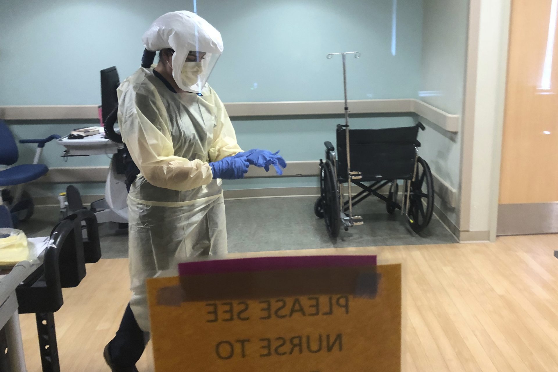 In this photo provided by the UPMC, Dr. Ruba Nicola, chairwoman of family medicine at UPMC East, adjusts her personal protective equipment at the UPMC East hospital in Monroeville, Pa., on April 17, 2020. The University of Pittsburgh Medical Centerâ€™s 40 hospitals in Pennsylvania, New York, Maryland and Ohio joined a study underway in the United Kingdom, Australia and New Zealand that randomly assigns patients to one of dozens of possible treatments and uses artificial intelligence to adapt treatments, based on the results.