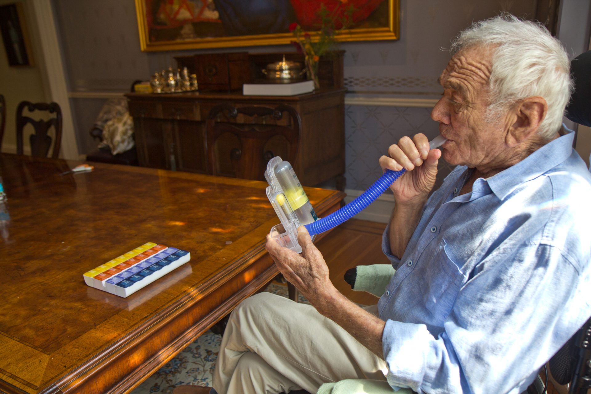 Avram Woidislawsky measures his lung capacity with a spirometer at home after a long hospital stay with COVID-19.