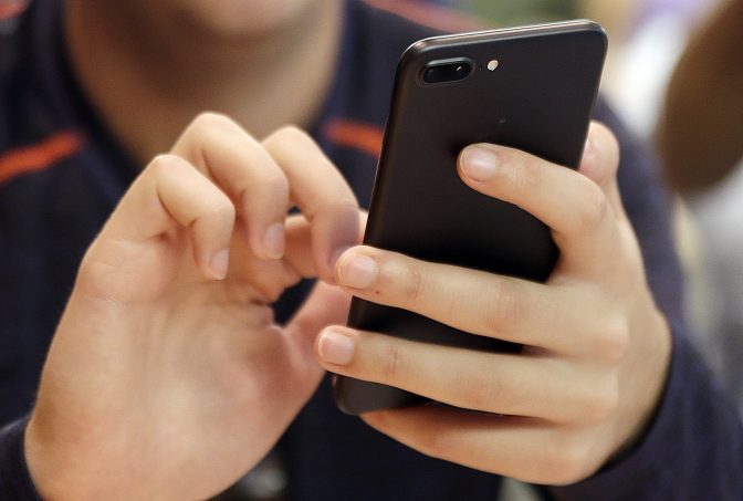 FILE PHOTO: In this Sept. 16, 2017, file photo, a teenager uses a smartphone.