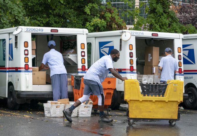 FILE PHOTO: In this July 31, 2020, file photo, letter carriers load mail trucks for deliveries at a U.S. Postal Service facility in McLean, Va.