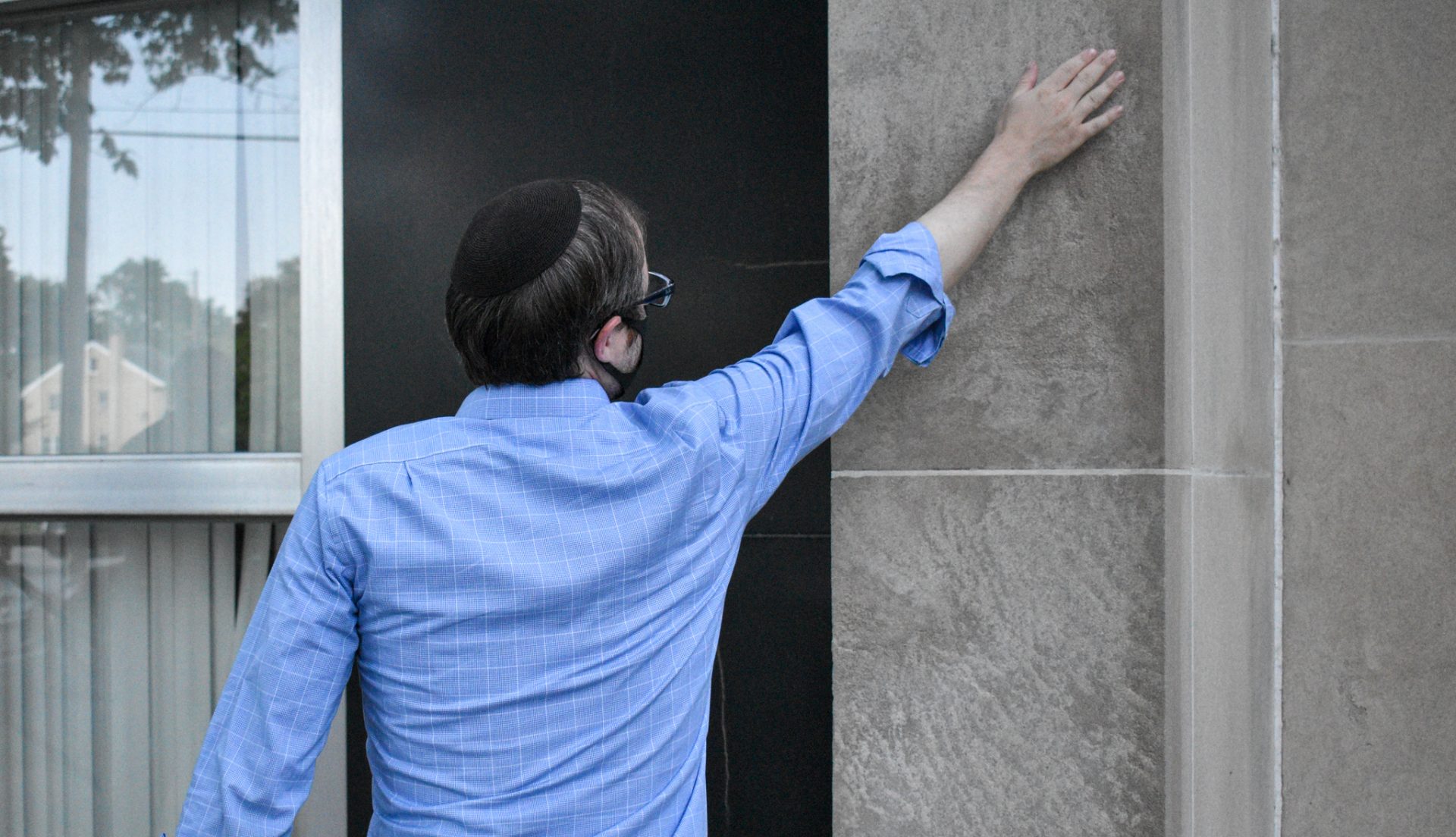 Rabbi Elisha Friedman touches the spot on the Kesher Israel Congregation synagogue where someone painted a swastika. It was found and removed on Monday, Aug. 10, 2020. The orthodox rabbi says security concerns have been a priority in recent years, especially after the 2018 Tree of Life Synagogue shooting in Pittsburgh.