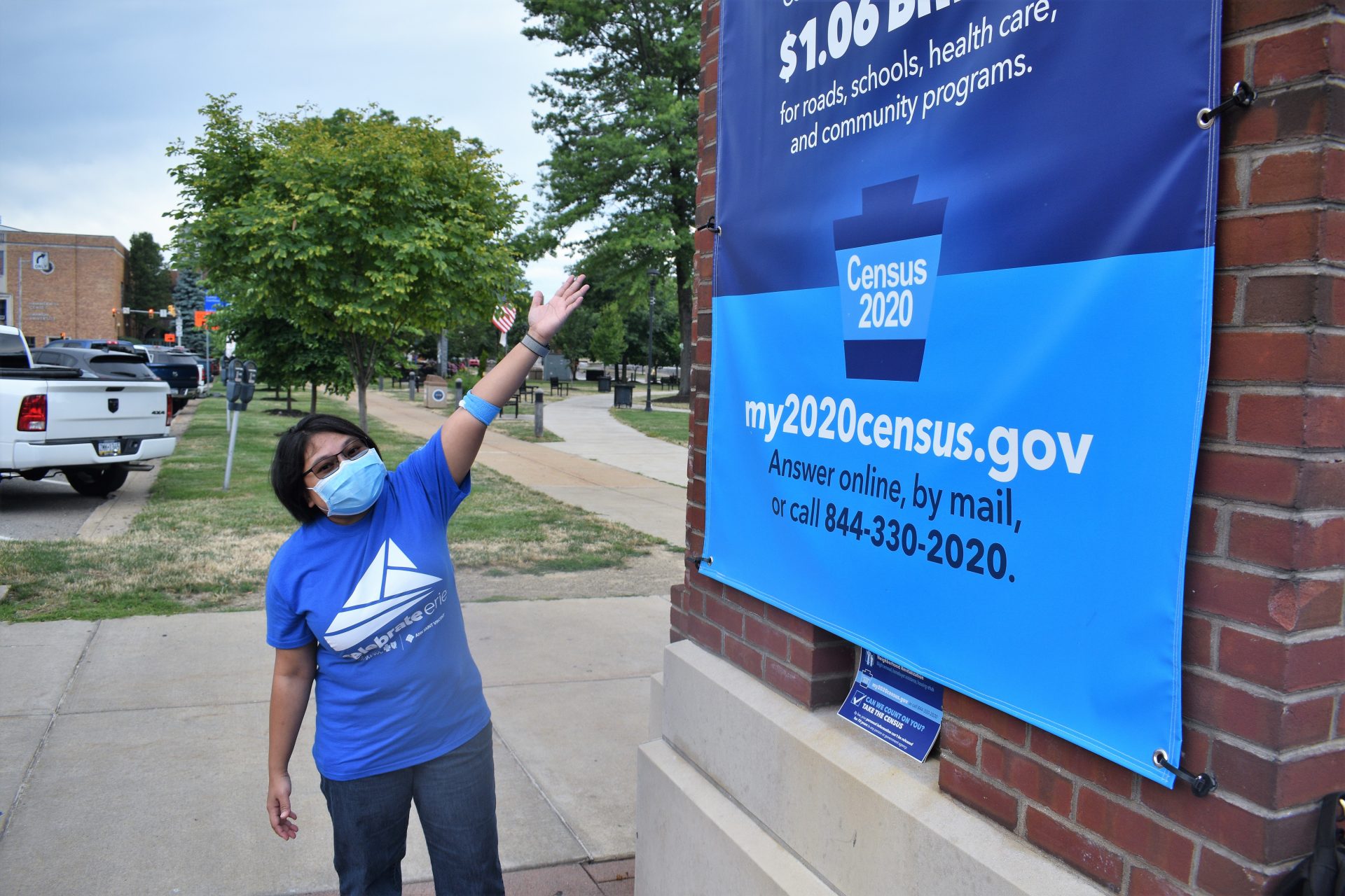 Niken Astari Carpenter, New American Liaison for the City of Erie, shows one of the banners in downtown Erie that are encouraging people to participate in the U.S. Census. The city estimates it loses $2,100 a year for every person who is not counted. In past census years, the city says refugees and immigrants have been undercounted.