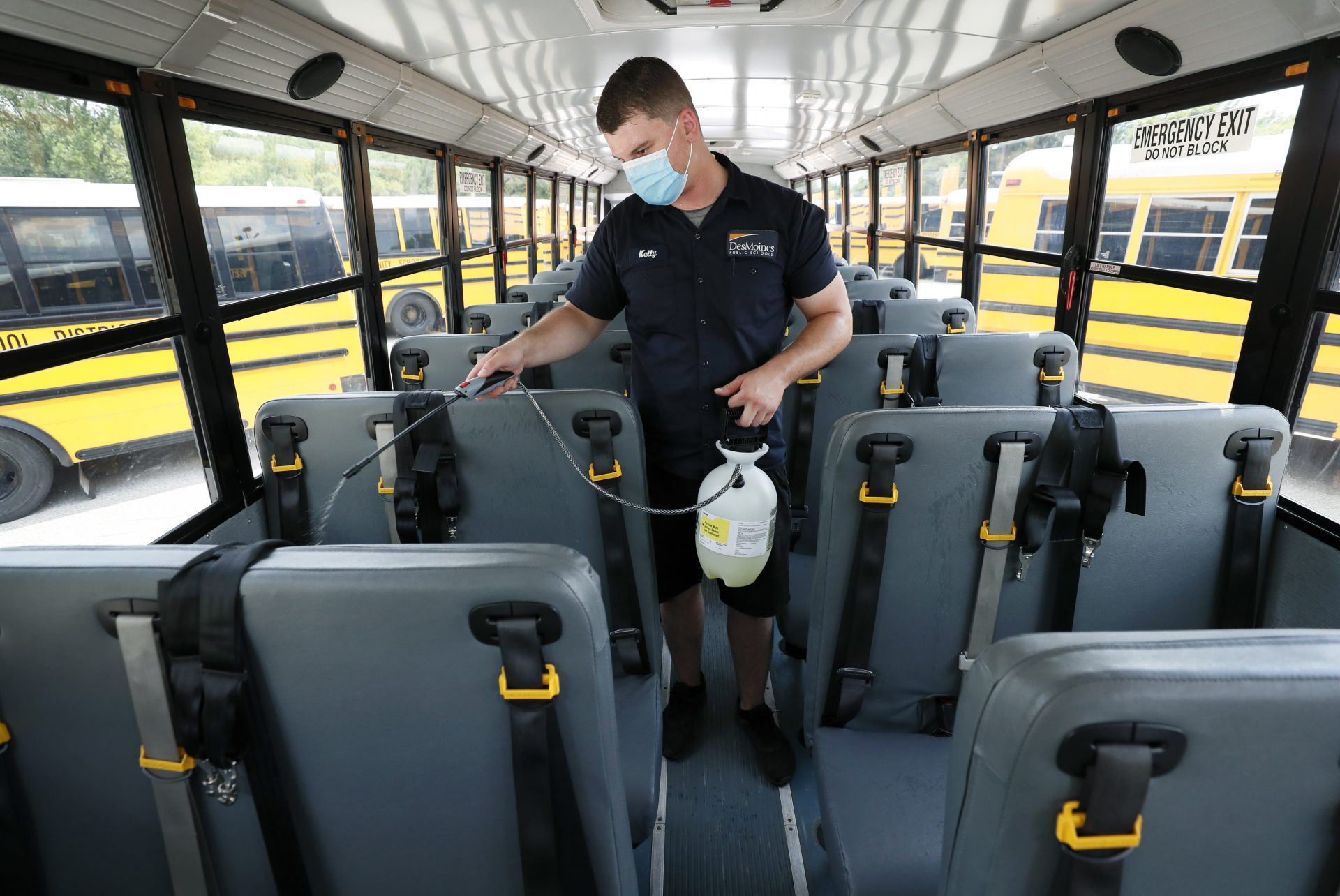 Des Moines Public Schools mechanic Kelly Silver cleans the interior of a school bus, Wednesday, July 29, 2020, in Des Moines, Iowa.