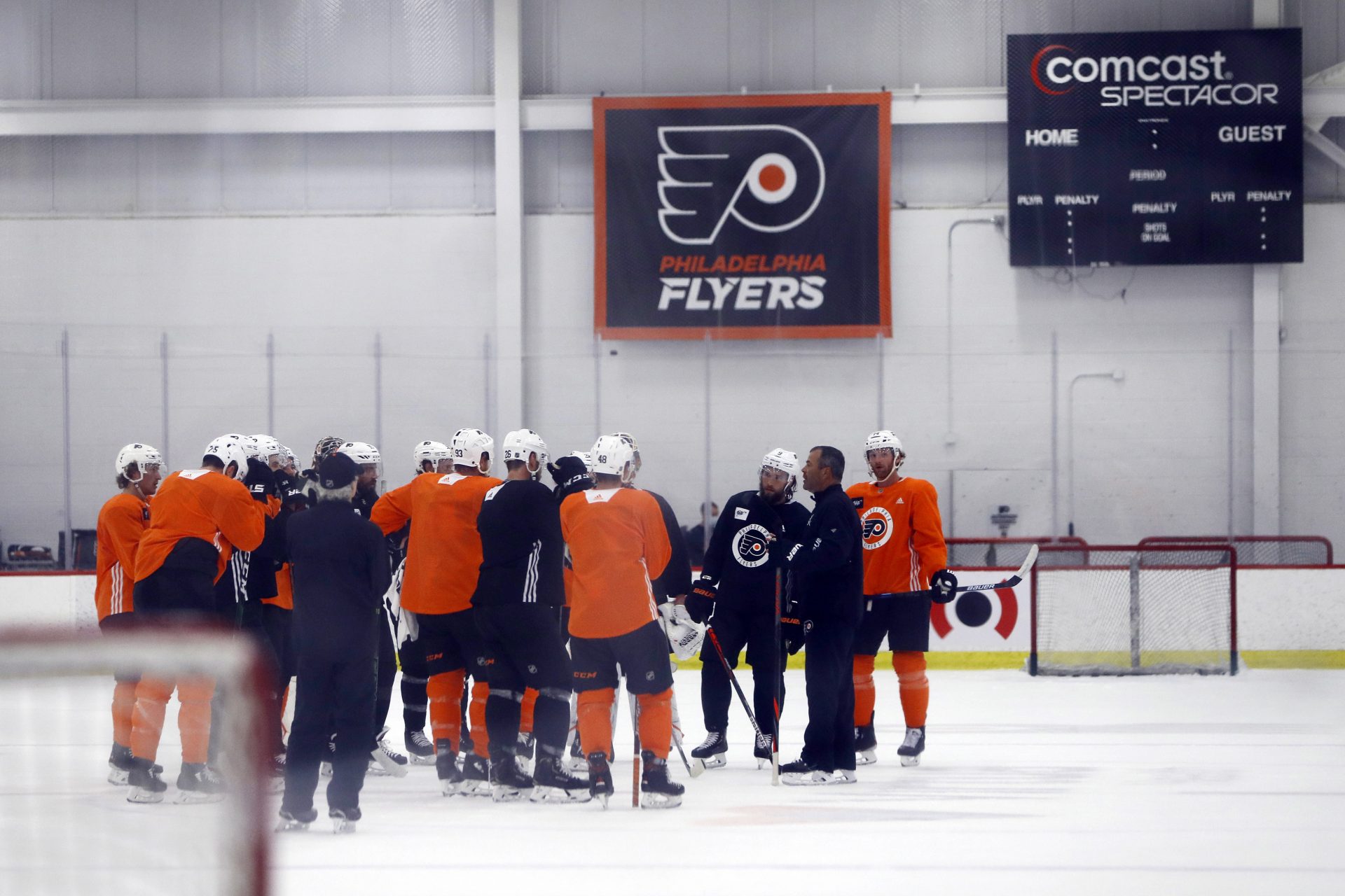 Philadelphia Flyers players gather with head coach Alain Vigneault, second from right, during training camp at the NHL hockey team's practice facility Monday, July 13, 2020, in Voorhees, N.J.