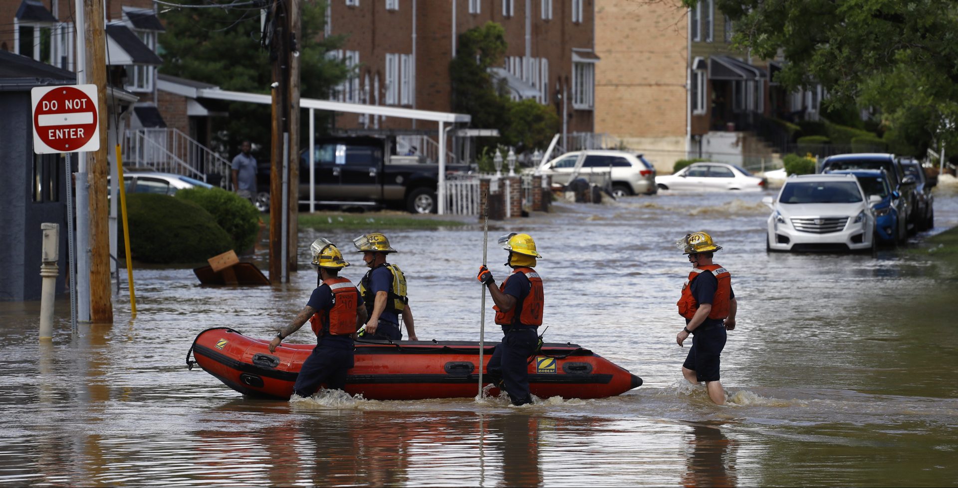 Philadelphia firefighters walk through a flooded neighborhood after Tropical Storm Isaias moved through, Tuesday, Aug. 4, 2020, in Philadelphia. The storm spawned tornadoes and dumped rain during an inland march up the U.S. East Coast after making landfall as a hurricane along the North Carolina coast.