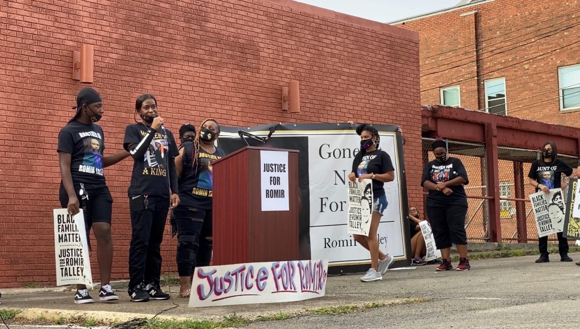 Latasha Talley, Romir Talley's mother, speaks at a protest in Wilkinsburg Saturday. Behind her is the wall where a mural for her son was painted in July.