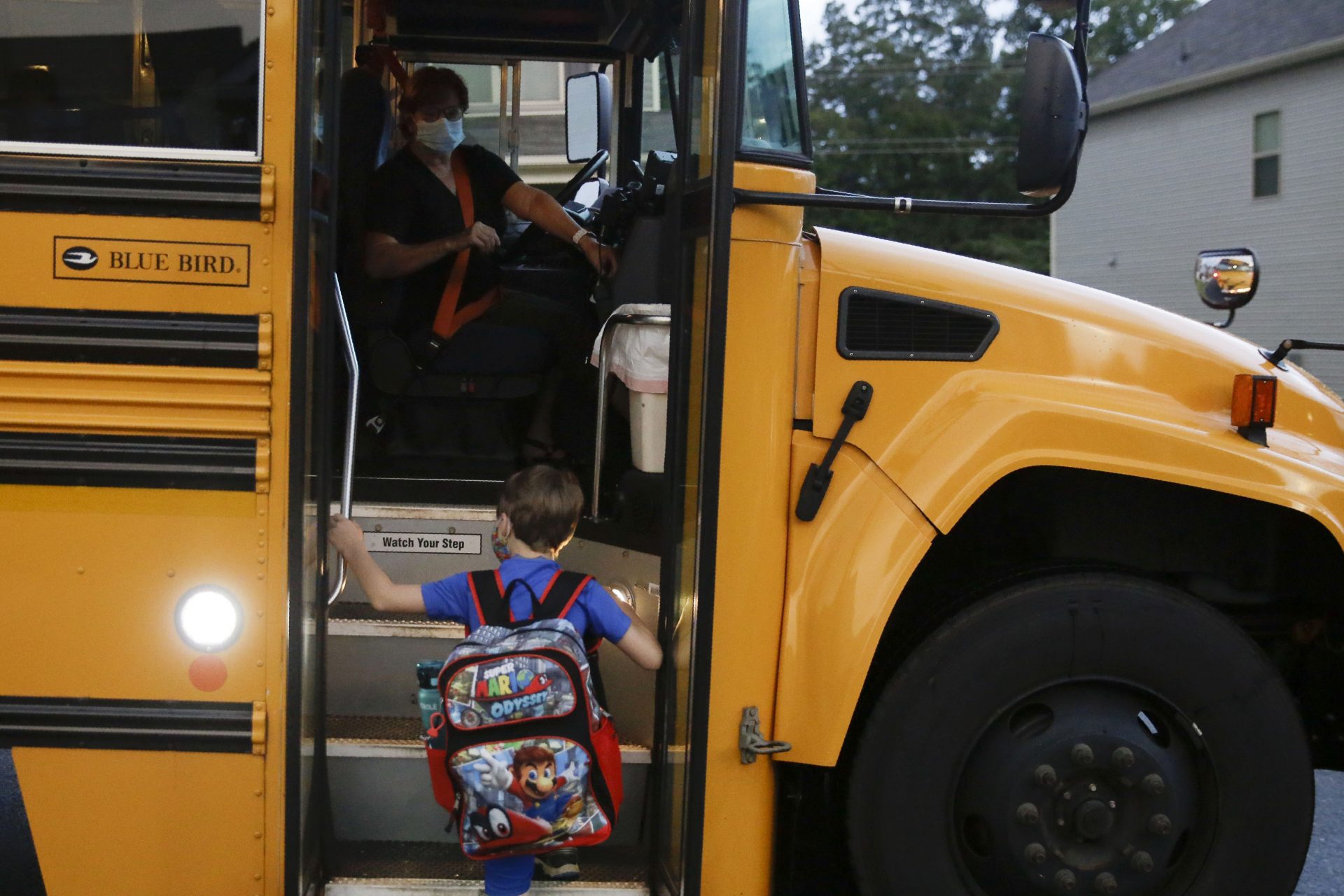 Paul Adamus, 7, climbs the stairs of a bus before the fist day of school on Monday, Aug. 3, 2020, in Dallas, Ga. Adamus is among tens of thousands of students in Georgia and across the nation who were set to resume in-person school Monday for the first time since March.