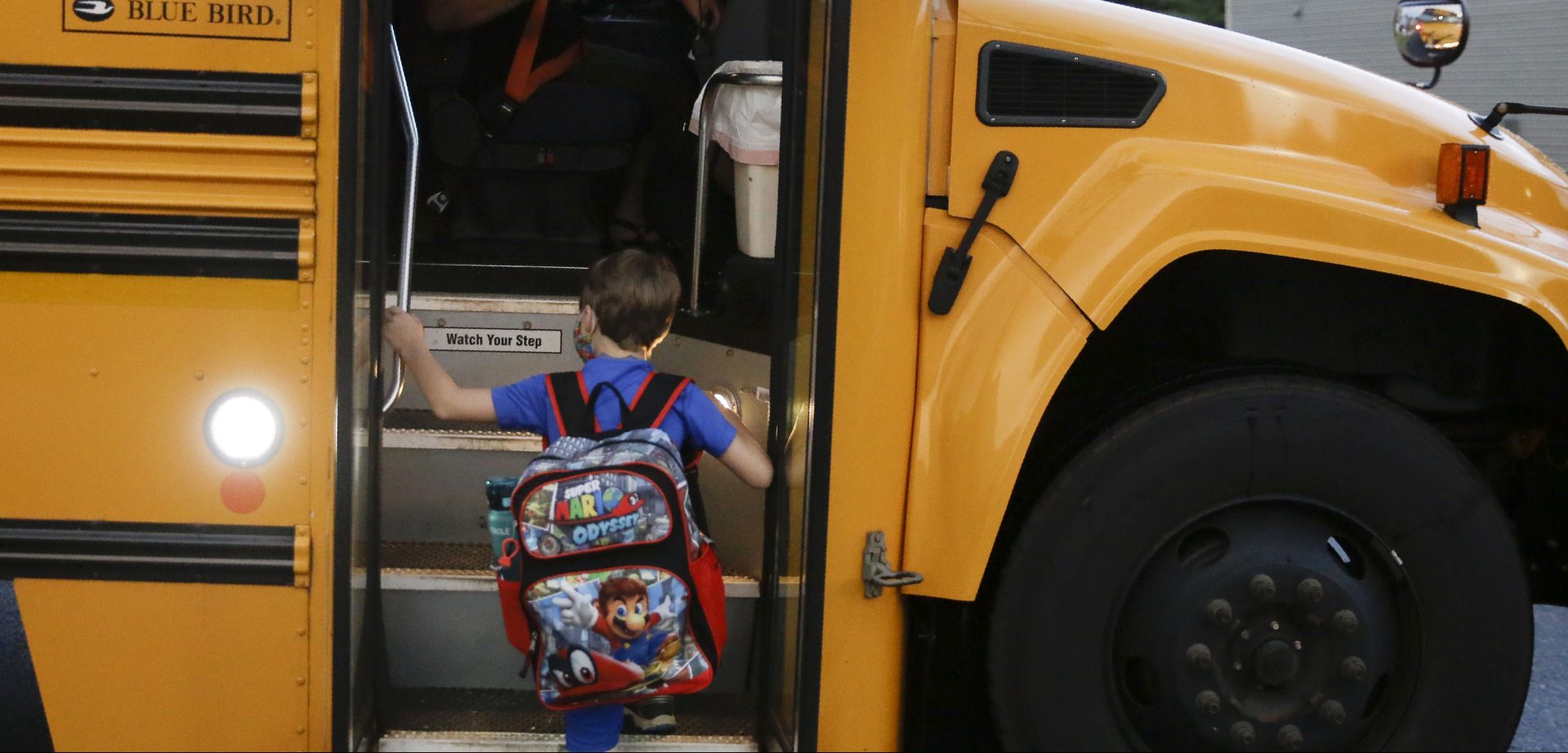 Paul Adamus, 7, climbs the stairs of a bus before the first day of school on Monday, Aug. 3, 2020, in Dallas, Ga. Adamus is among tens of thousands of students in Georgia and across the nation who were set to resume in-person school Monday for the first time since March. 