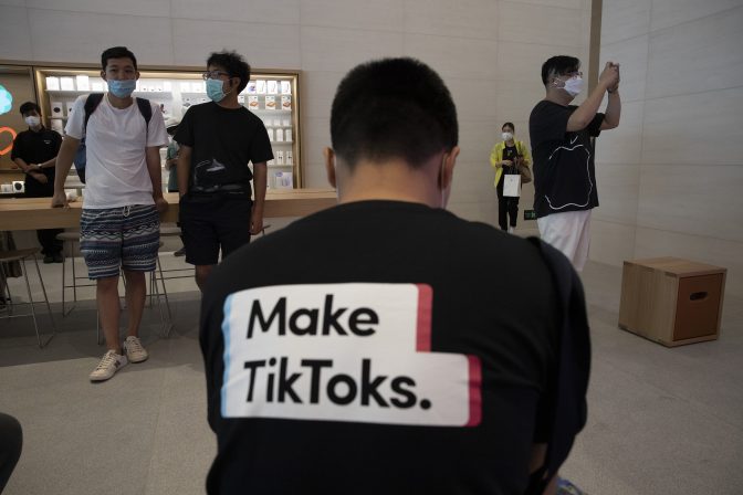 A man wearing a shirt promoting TikTok is seen at an Apple store in Beijing on Friday, July 17, 2020. U. S. President Donald Trump says he wants to take action to ban TikTok, a popular Chinese-owned video app that has been a source of national security and censorship concerns.