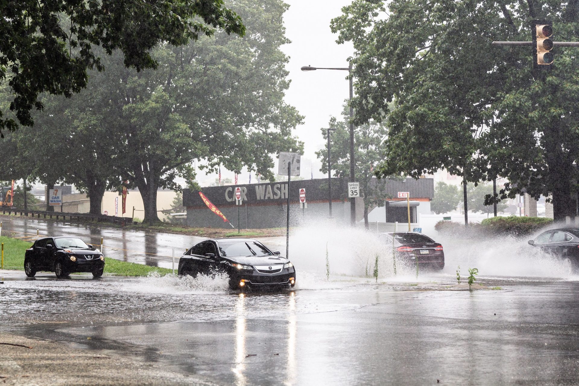 Cars plow through water at Ridge Avenue and Henry Avenue during Isaias’ rains Tuesday.