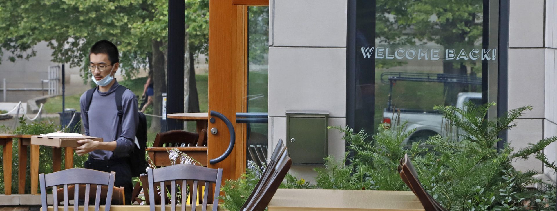 A man walks out of the Porch restaurant with his takeout order on Thursday, July 9, 2020 in the Oakland neighborhood of Pittsburgh. Due to a spike in COVID-19 infections, service at restaurants has been limited to takeout for the past week. Beginning Friday, restaurants will re-open for outside dining only.