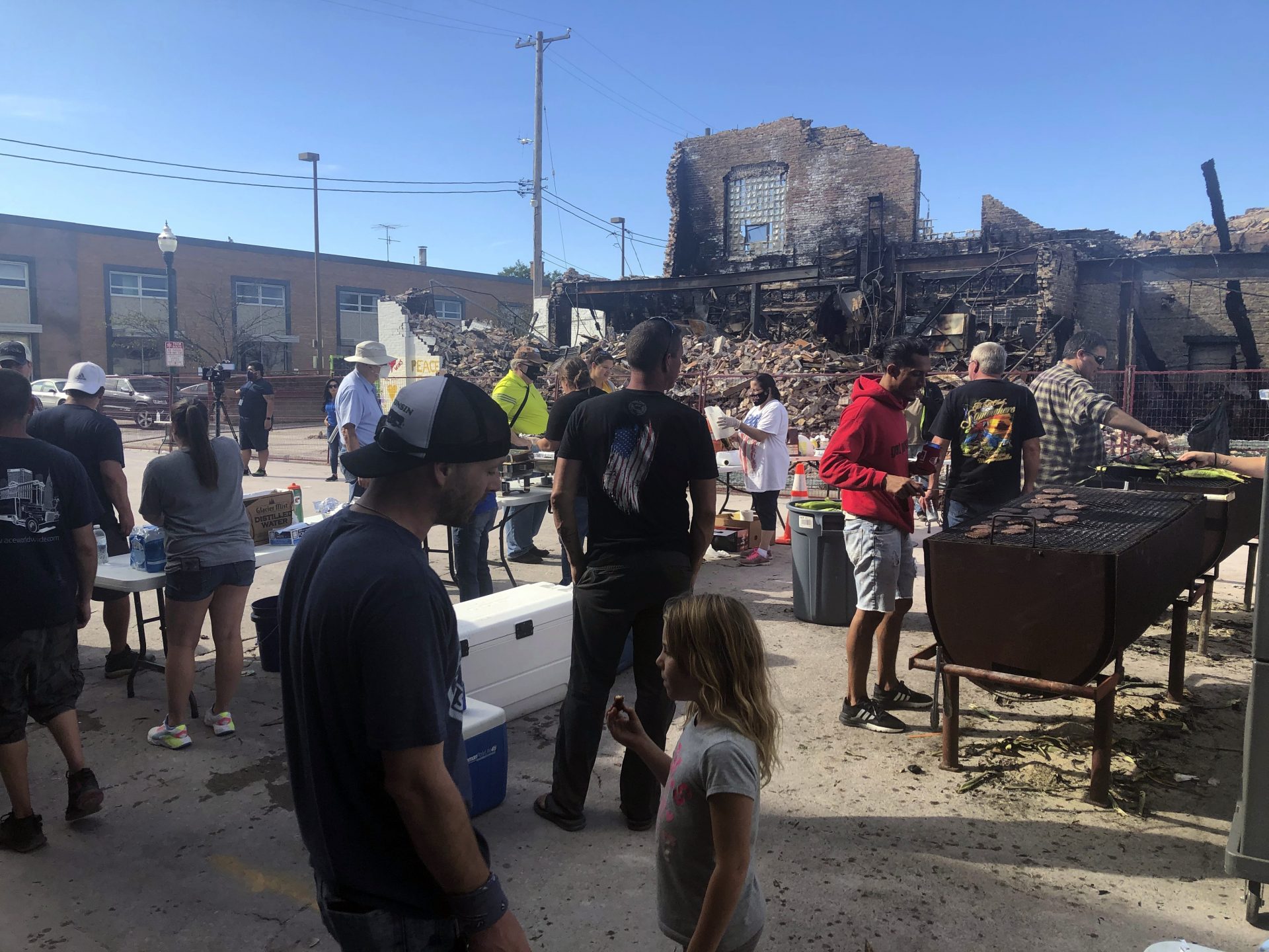Volunteers prepare hamburgers for mural painting volunteers working in front of one of the city's dozens of burnt buildings in Kenosha, Wis., Sunday, Aug. 30, 2020. The southern Wisconsin city remained on edge following the police shooting of Jacob Blake, a Black man, and the violent protests that followed.