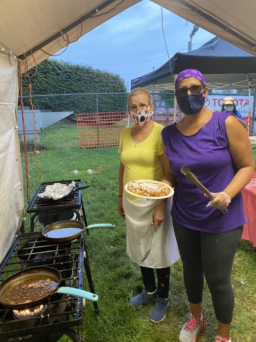 Nelsa Lopez learned how to make funnel cakes when her children were young. Now, she makes them every year for her church's Hispanic festival in Lancaster, with help from her mother (left). This year, she is the only vendor selling dessert. (Alanna Elder/WITF)