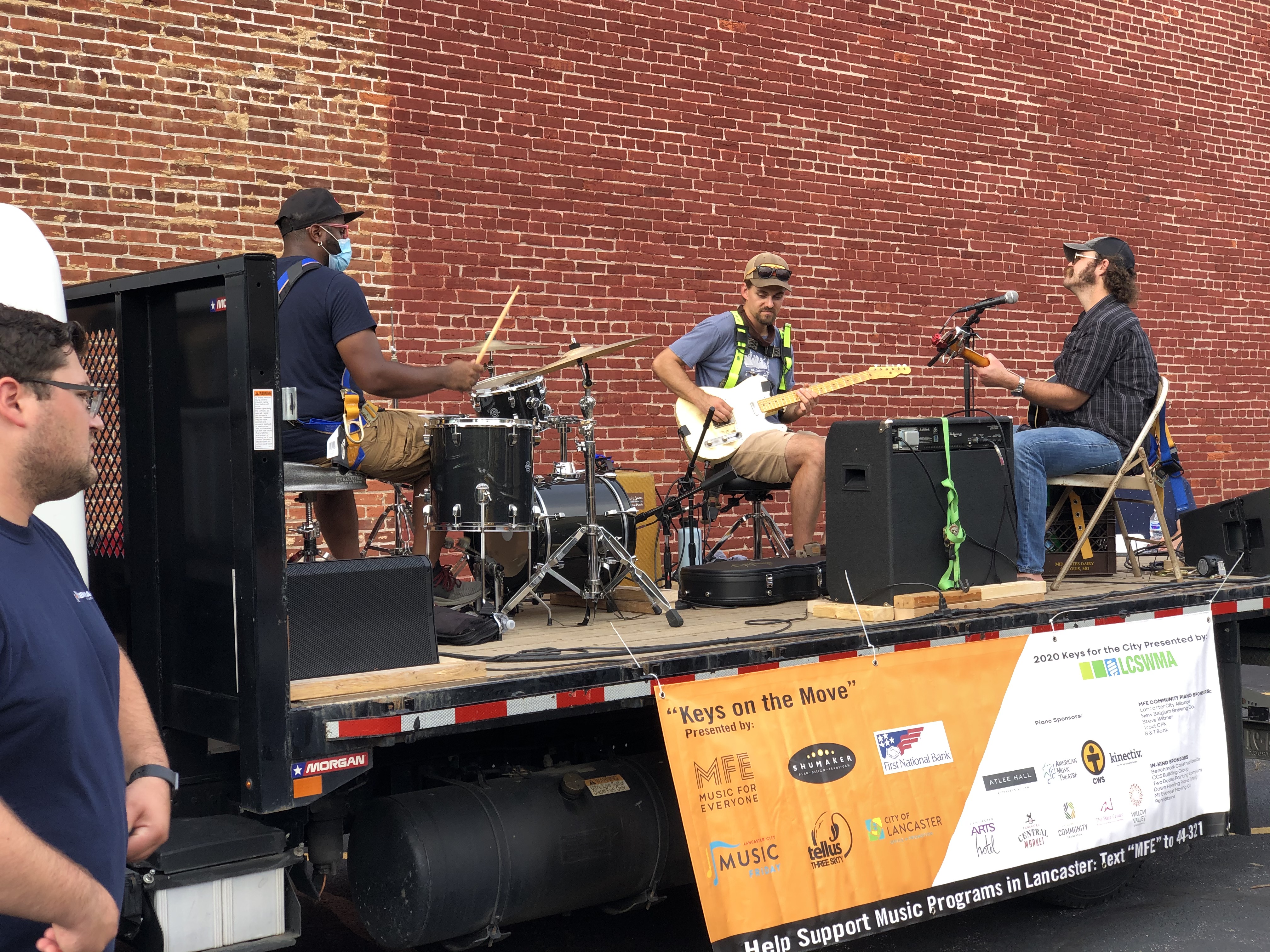 Andy Mowatt and his band performing on a flatbed truck.