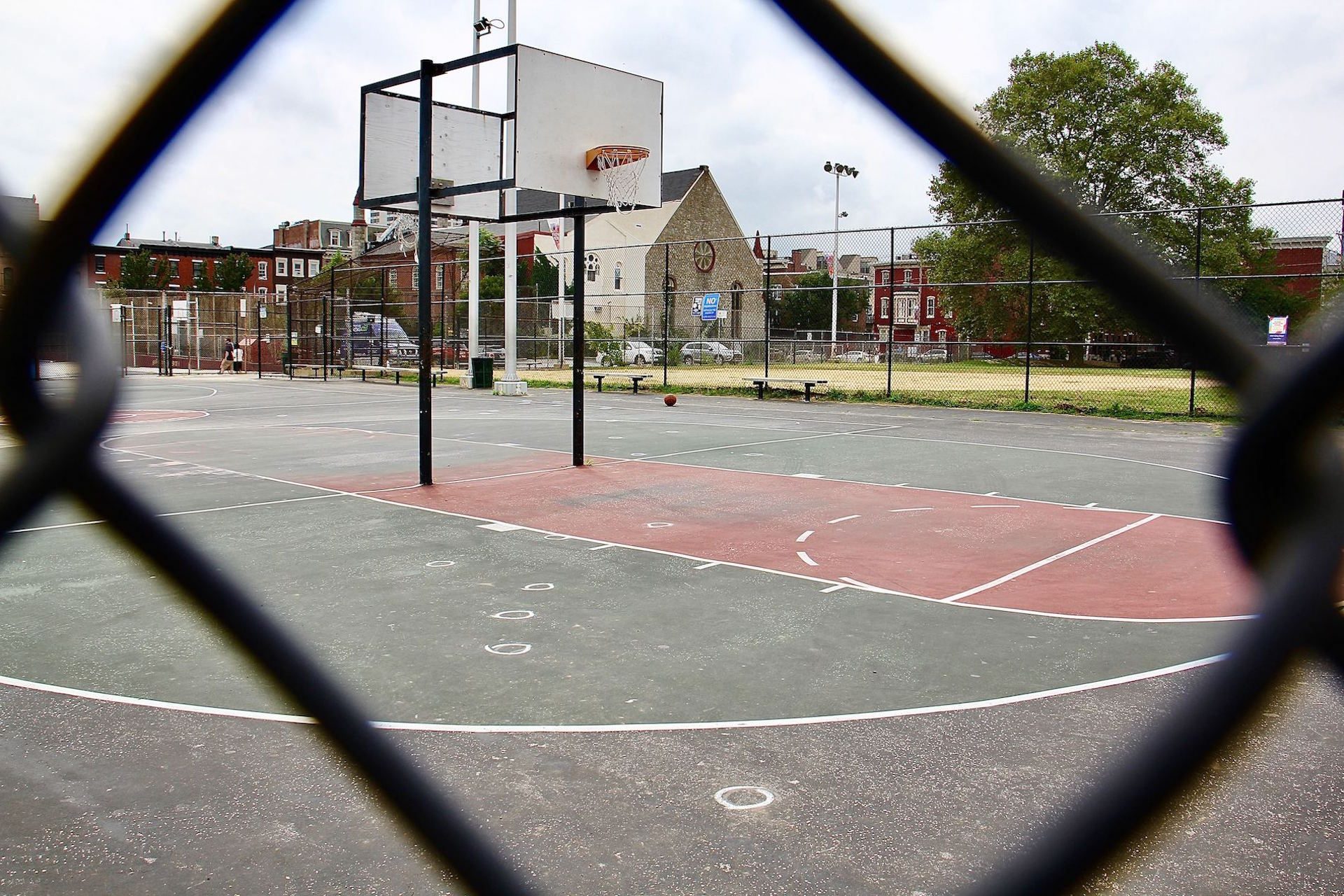 The basketball court at Roberto Clemente Playground is padlocked after five people were shot, two fatally. Chalk circles mark where bullet casings fell.