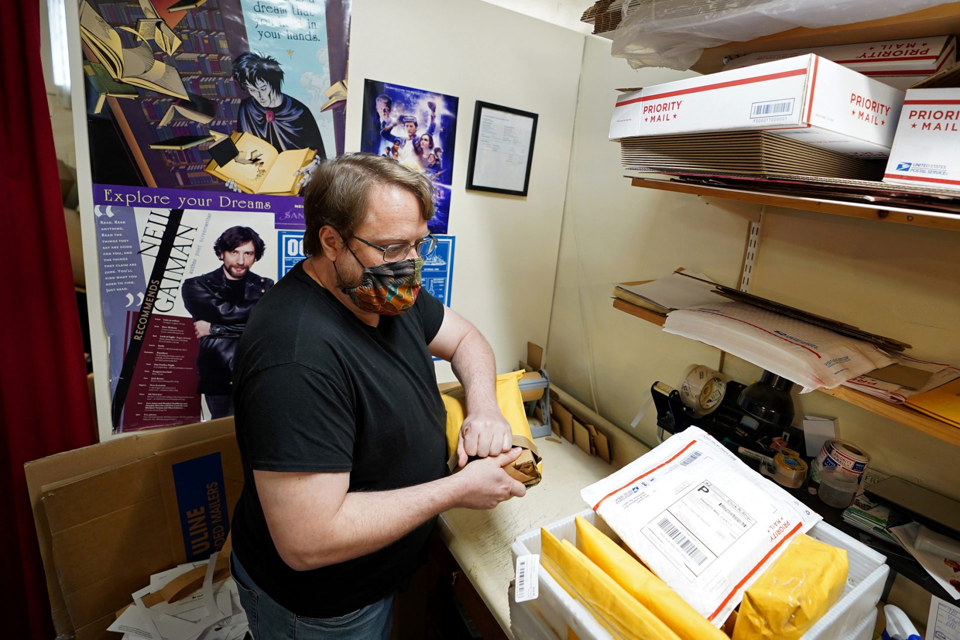 Firefly Bookstore co-owner Matthew Williams packs up a book to ship to a customer as it has become a big part of the business due to the COVID-19 pandemic and recent spike in cases due to the return of students to nearby Kutztown University.