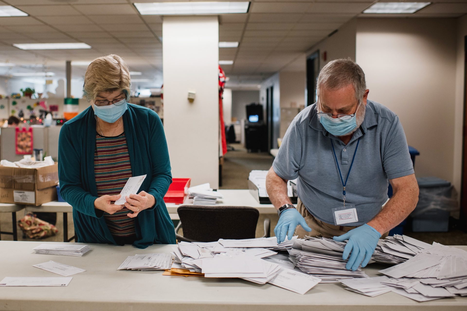 Andrea Lerner (left), and her husband, Ira Lerner, sift through the mail-in applications at the Voter Registration office in the Lehigh County Government Center in Allentown, Pa.