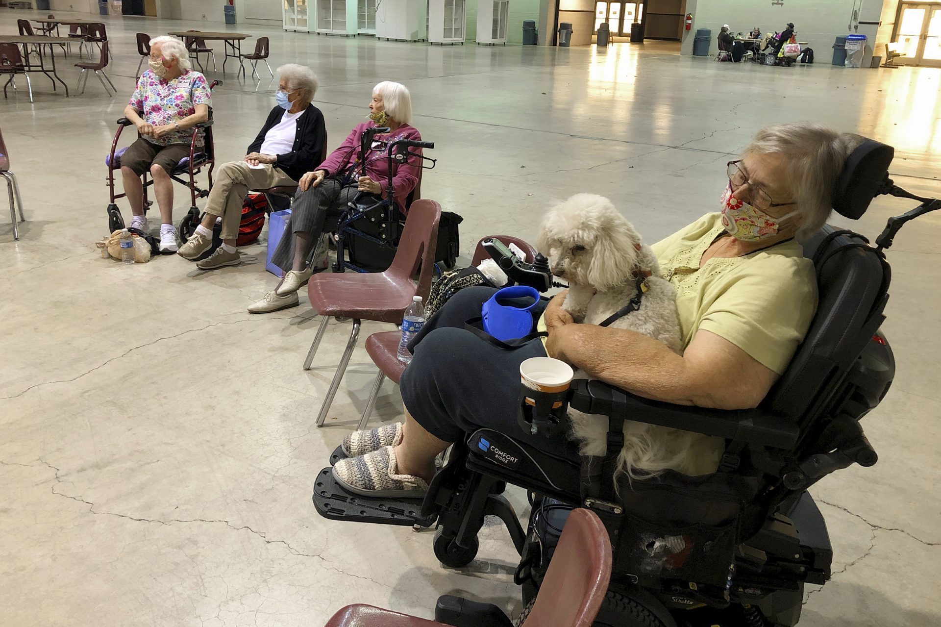 Patricia Fouts sits with her dog, Murphy, and other evacuated residents of a senior living home in an evacuation center at the Oregon State Fairgrounds in Salem, Ore., on Tuesday. Marian Estates senior living home in Sublimity, Ore., was evacuated early Tuesday as a wildfire closed in on the area.