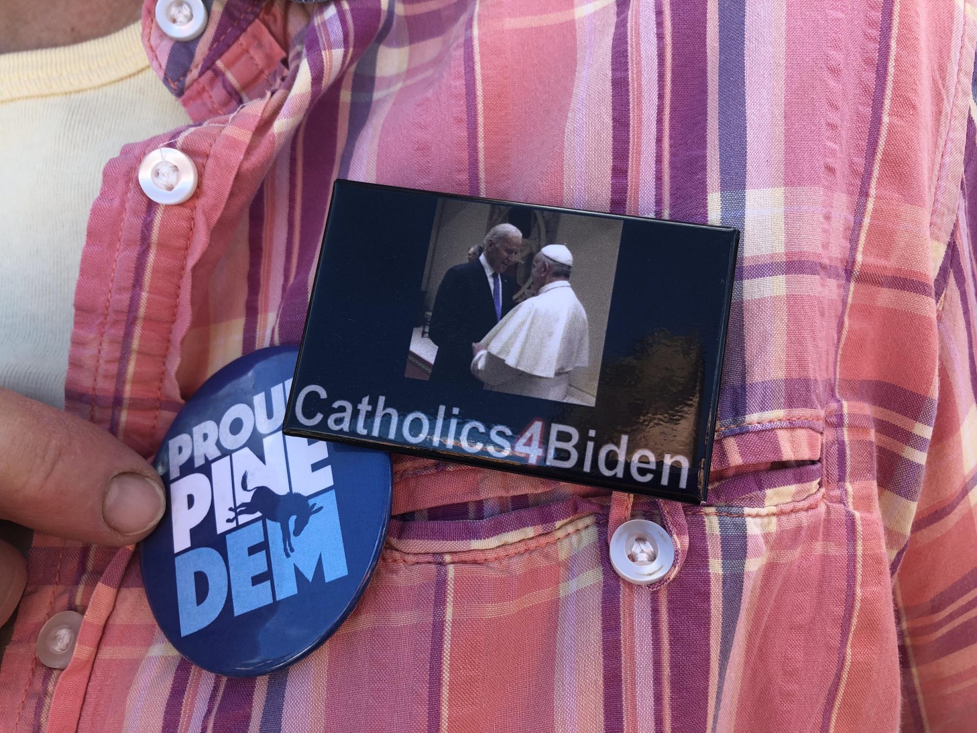 A Democratic voter displays a pin of Joe Biden meeting with Pope Francis.
