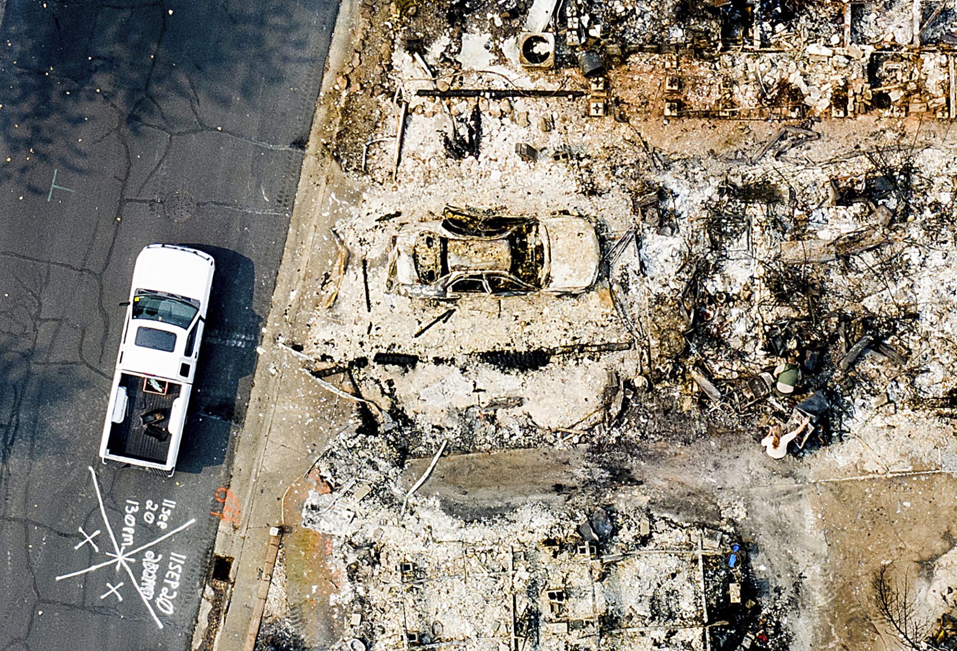 This aerial image taken with a drone, a person searches through the remains of a home leveled by the Almeda Fire at Bear Lake Estates in Phoenix, Ore., on Tuesday, Sept. 15, 2020.