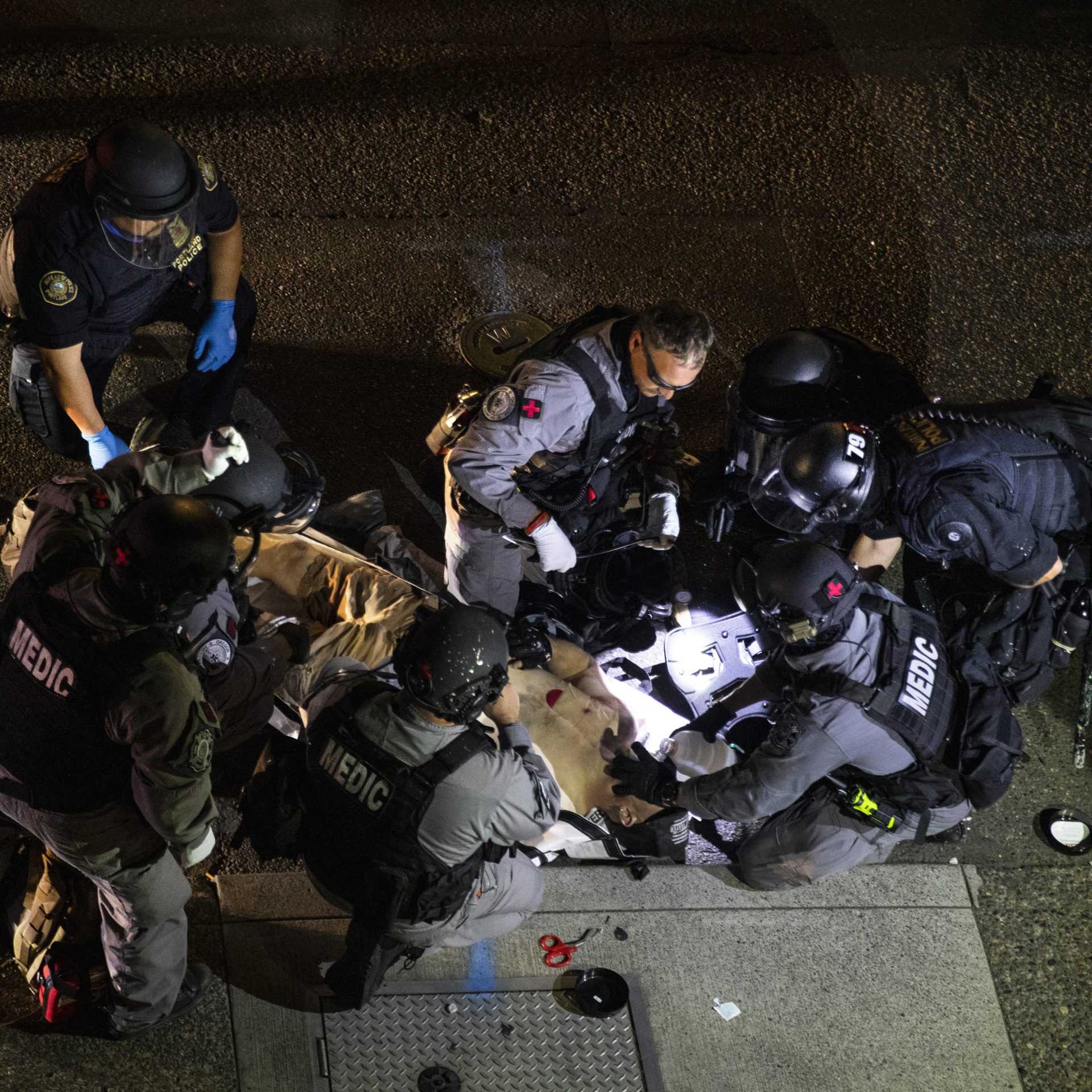 A man is treated after being shot Saturday, Aug. 29, 2020, in Portland, Ore. It wasn’t clear if the fatal shooting late Saturday was linked to fights that broke out as a caravan of about 600 vehicles was confronted by counterdemonstrators in the city’s downtown.