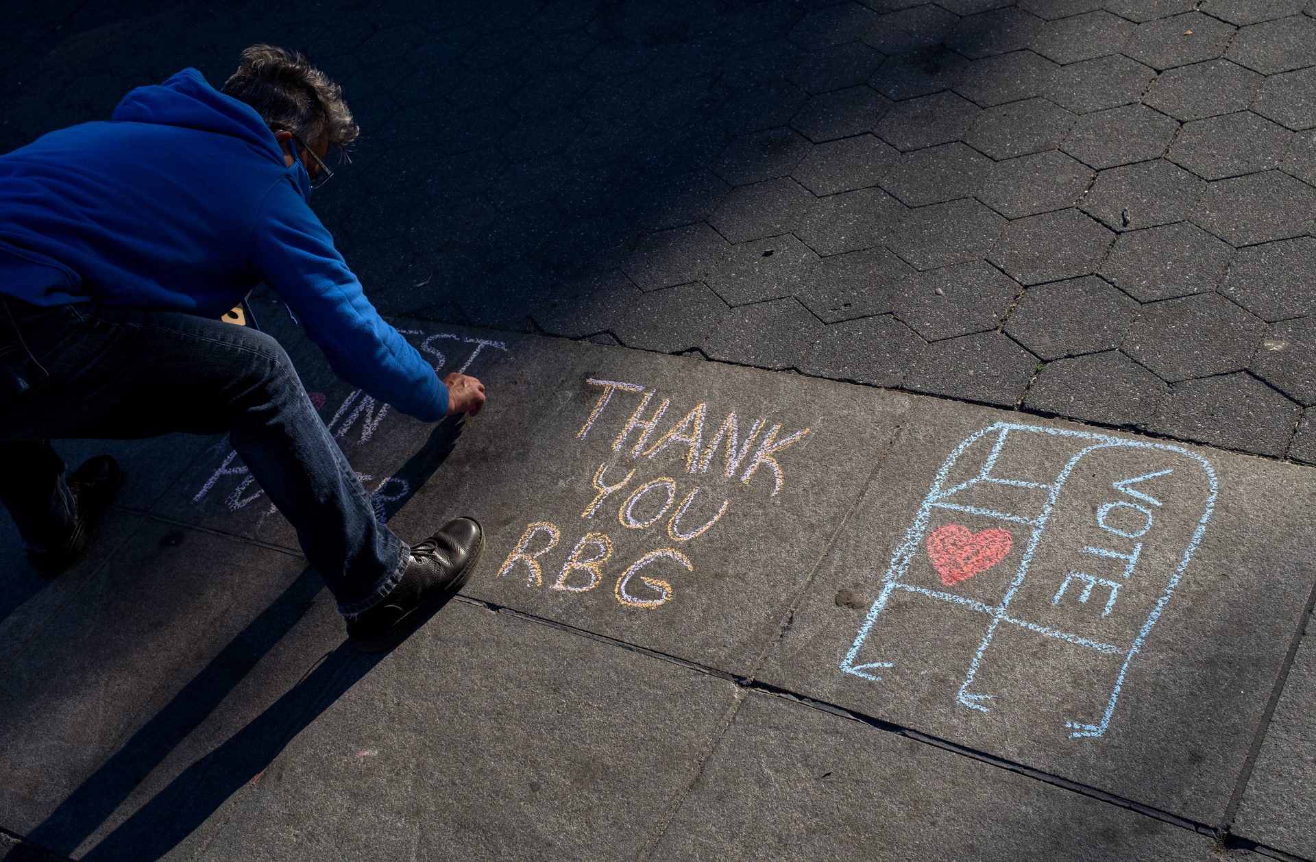 Kimberly Miller, of the Brooklyn borough of New York, who is with Gays Against Guns, leaves a chalk message honoring Justice Ruth Bader Ginsburg on a Washington Square Park walkway in New York Saturday, Sept. 19, 2020, a day after the death of the Supreme Court justice.