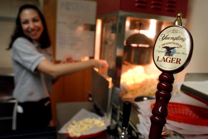 Yuengling Lager is on tap at the Cinema & Drafthouse in West Hazelton, Pa., Friday, May 30, 2003, as waitress Amy Michelli readies some popcorn for customers. The Hersker Theater is now the Cinema & Drafthouse, the only movie theater in eastern Pennsylvania where the patrons can get a beer or mixed drinks and order dinner off the menu while enjoying a show.