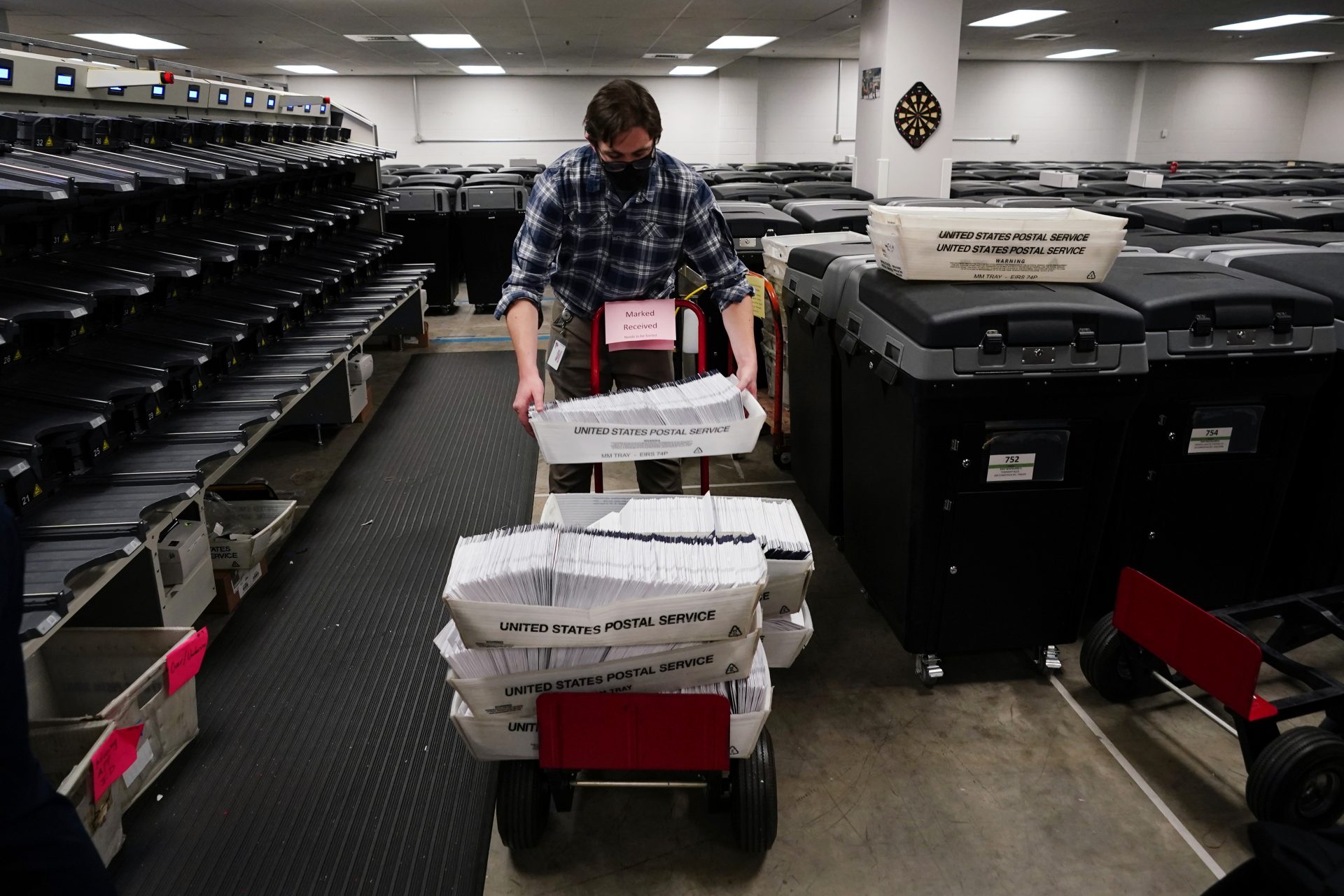 Michael Imms, with Chester County Voter Services, gathers mail-in ballots after being sorted for the 2020 General Election in the United States, Friday, Oct. 23, 2020, in West Chester, Pa.