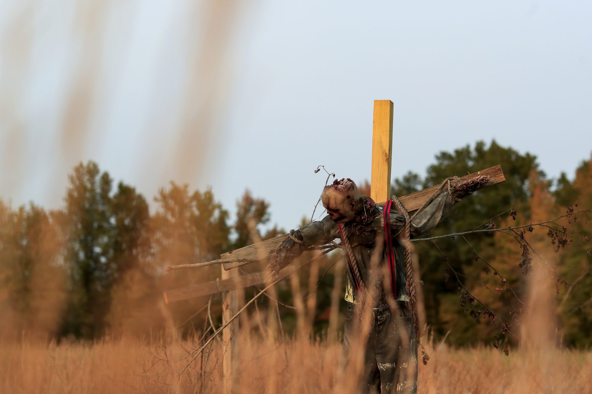 A scarecrow hangs from a cross on the haunted trail of Terror Town, Saturday, Oct. 17, 2020, in Williamsburg, Ohio. In a year when fear and death have commandeered front-row seats in American life, what does it mean to encounter Halloween, a holiday whose very existence hinges on turning fear and death into entertainment?