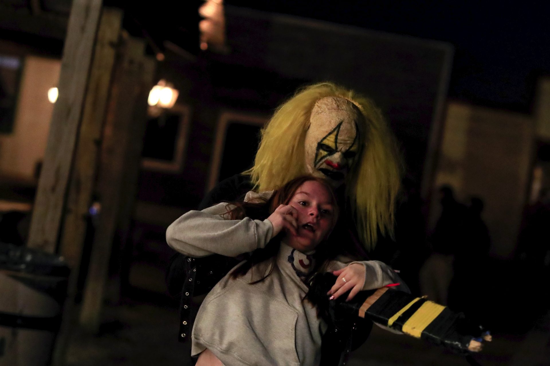 An cast member dressed as a clown grabs and drags away a visitor of Terror Town, Saturday, Oct. 17, 2020, in Williamsburg, Ohio.