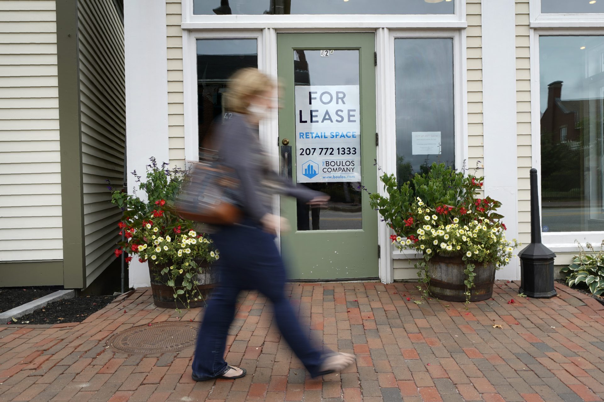 In this Sept. 2, 2020, file photo, a shopper walks by one of several vacant retail spaces among the outlet shops in Freeport, Maine. The U.S. unemployment rate dropped to 7.9% in September, but hiring is slowing and many Americans have given up looking for work, the government said Friday, Oct. 2, in the final jobs report before the voters decide whether to give President Donald Trump another term.