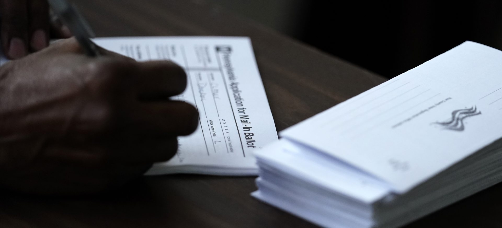 In this Sept. 29, 2020, file photo Philadelphia City Council President Darrell L. Clarke fills out an application for a mail-in ballot before voting at the opening of a satellite election office at Temple University's Liacouras Center in Philadelphia. Pennsylvania has seen a frenzy of election-related lawsuits as state officials prepare for some 3 million people, about half the expected turnout, to cast mail-in ballots.