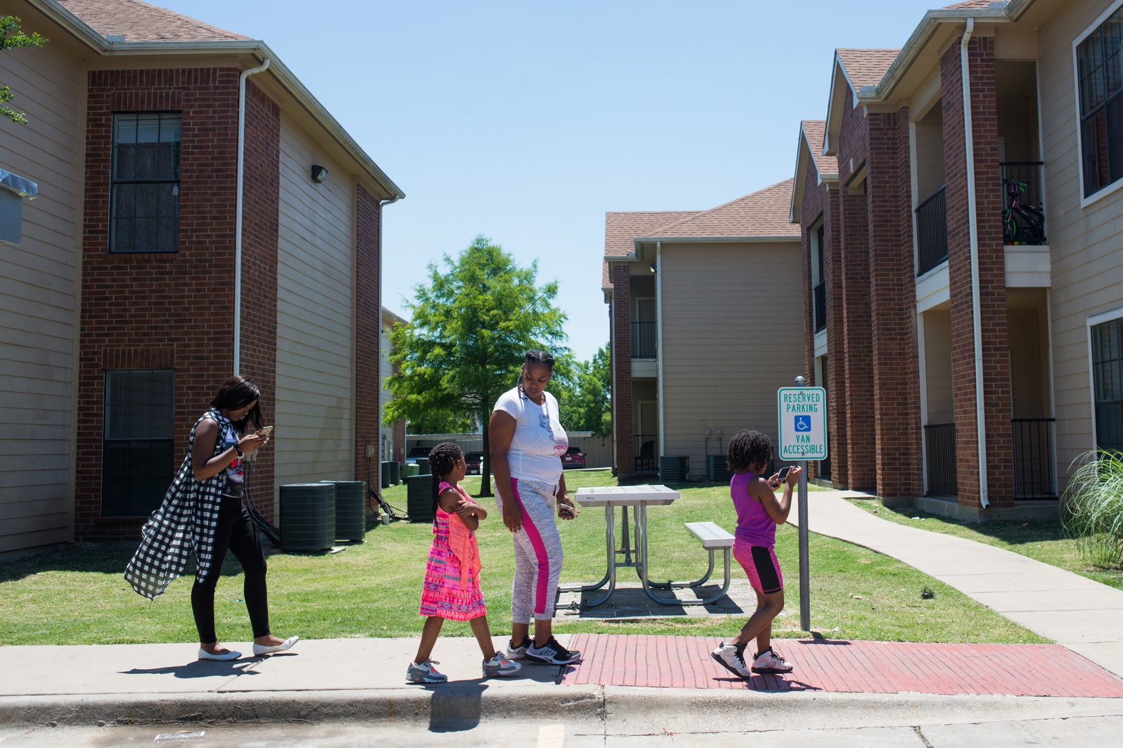C'Artis Harris, walking with her children in 2017, was searching for housing that would accept her Section 8 voucher when NPR began following her in 2016. Today, Harris and her family still live in an area of high poverty.